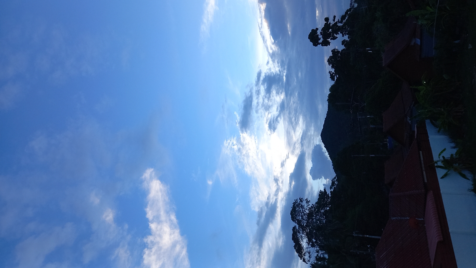 Twilight clouds drift over Ko Pha-ngan rooftops near the sea
