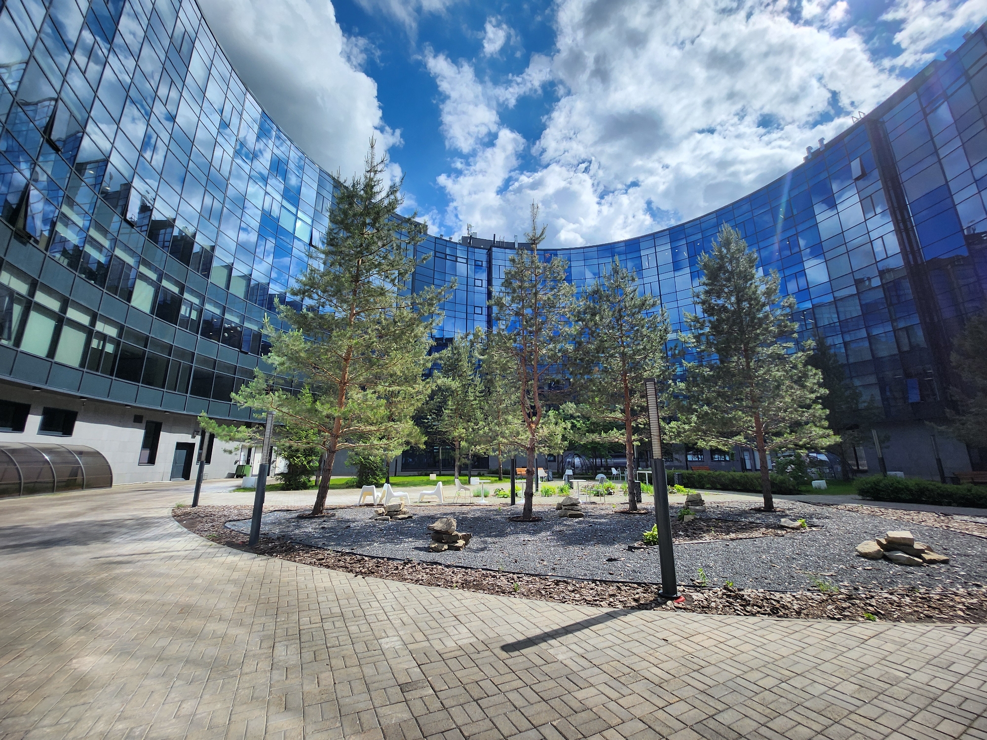 Three people gather in modern office building courtyard