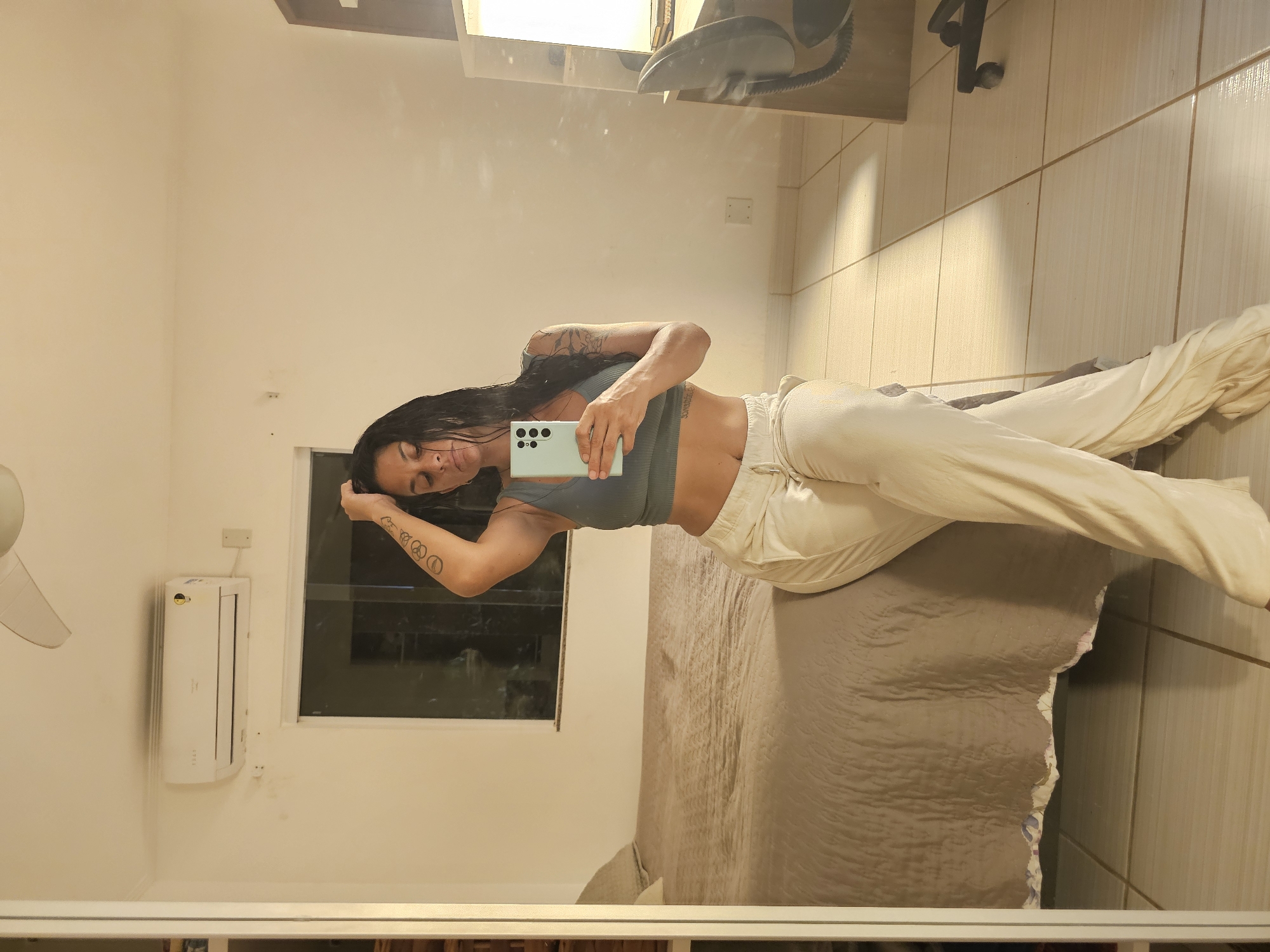 Woman takes mirror selfies in Cabo Frio bedroom