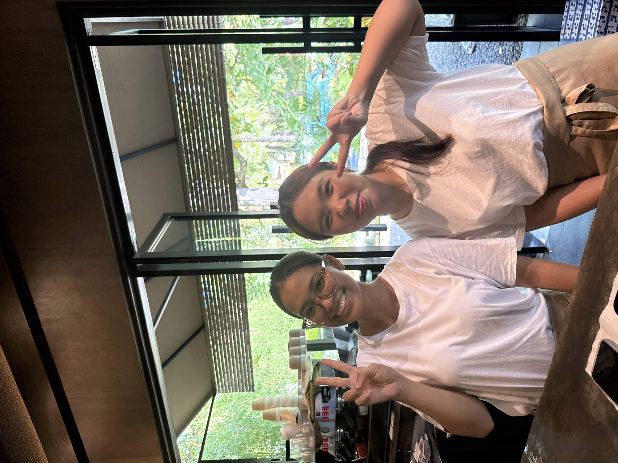 Young women pose at Kuta Selatan cafe with friendly barista