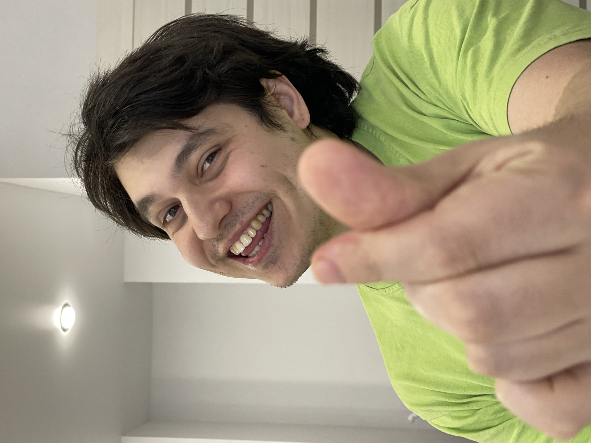 Man in lime shirt points at camera in Izhevsk