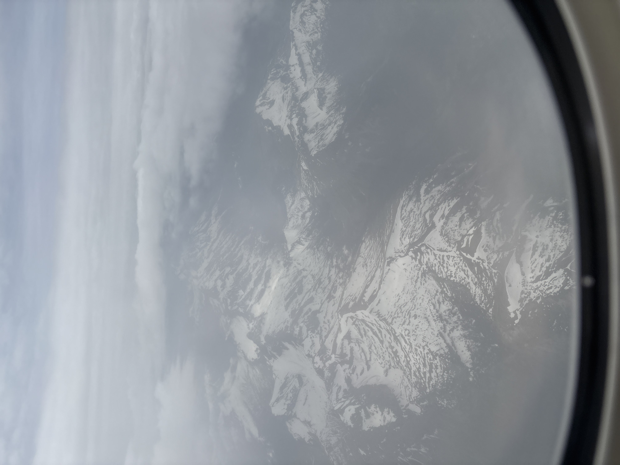 Aircraft passenger photographs cloudy mountain view over Quart, Italy