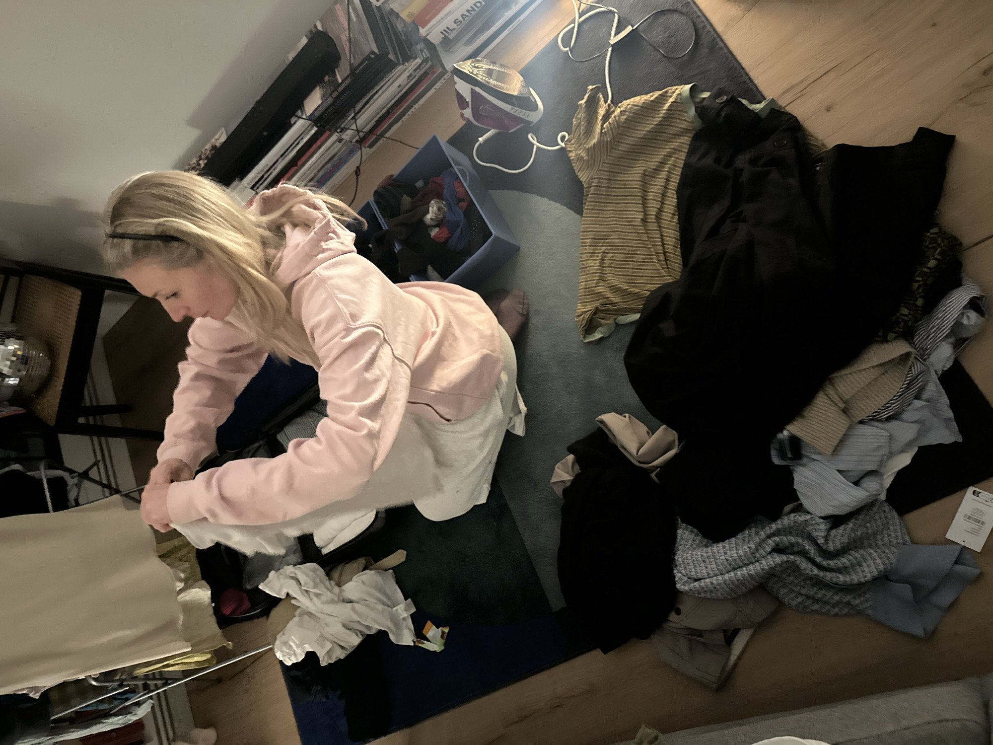 Woman folding laundry at home in London evening