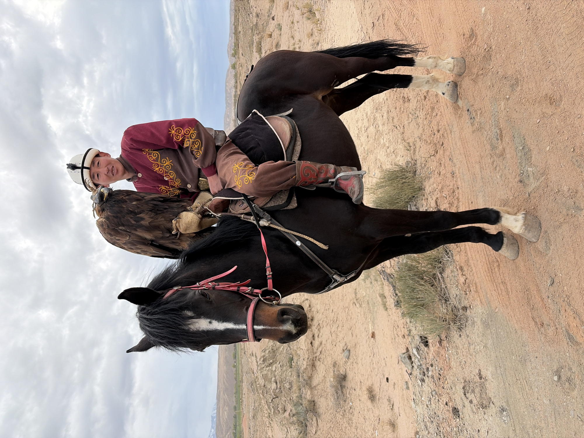 Eagle hunter poses with bird on horseback in Kyrgyzstan