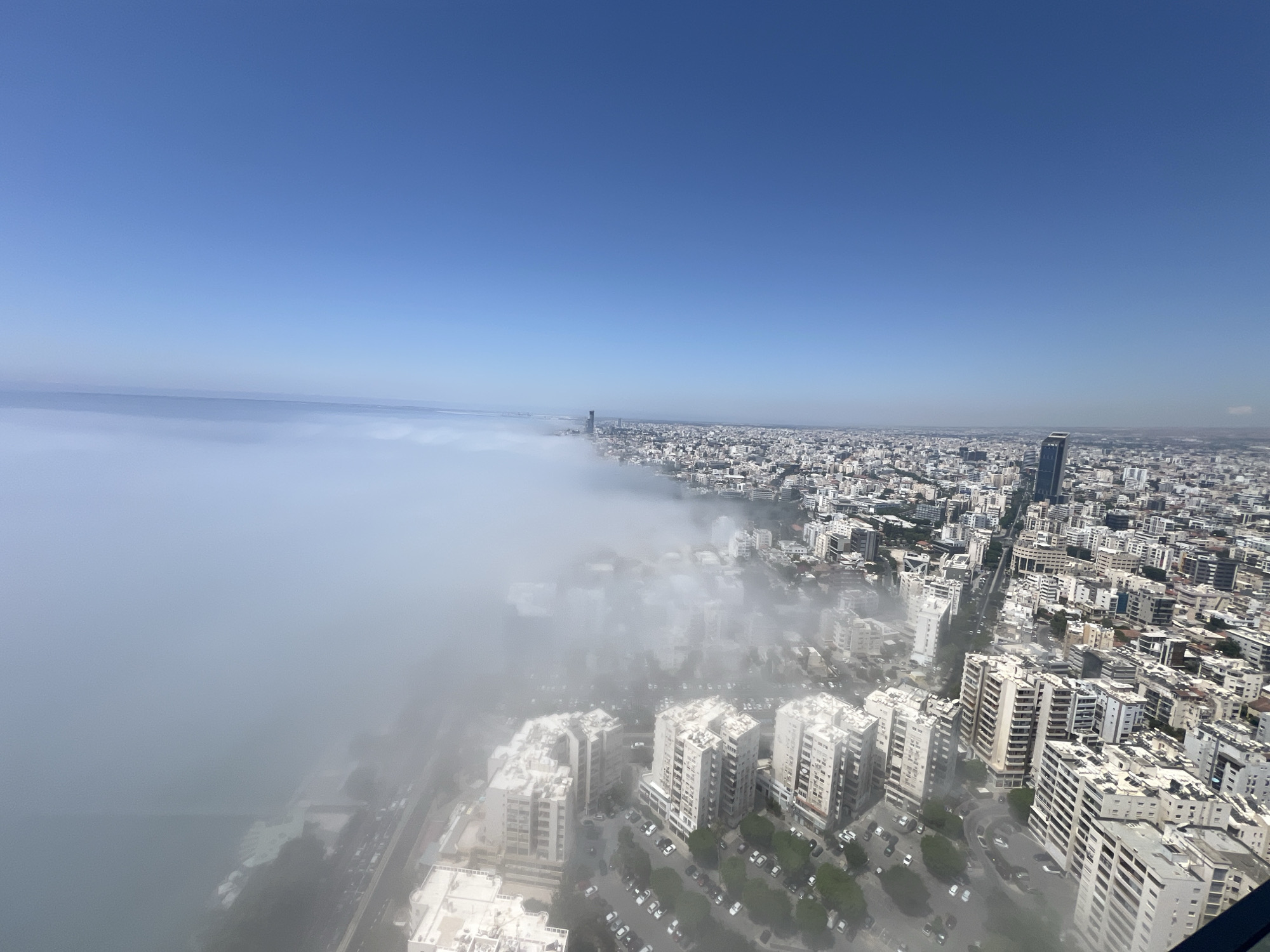 Morning fog rolls over Limassol's coastline from above