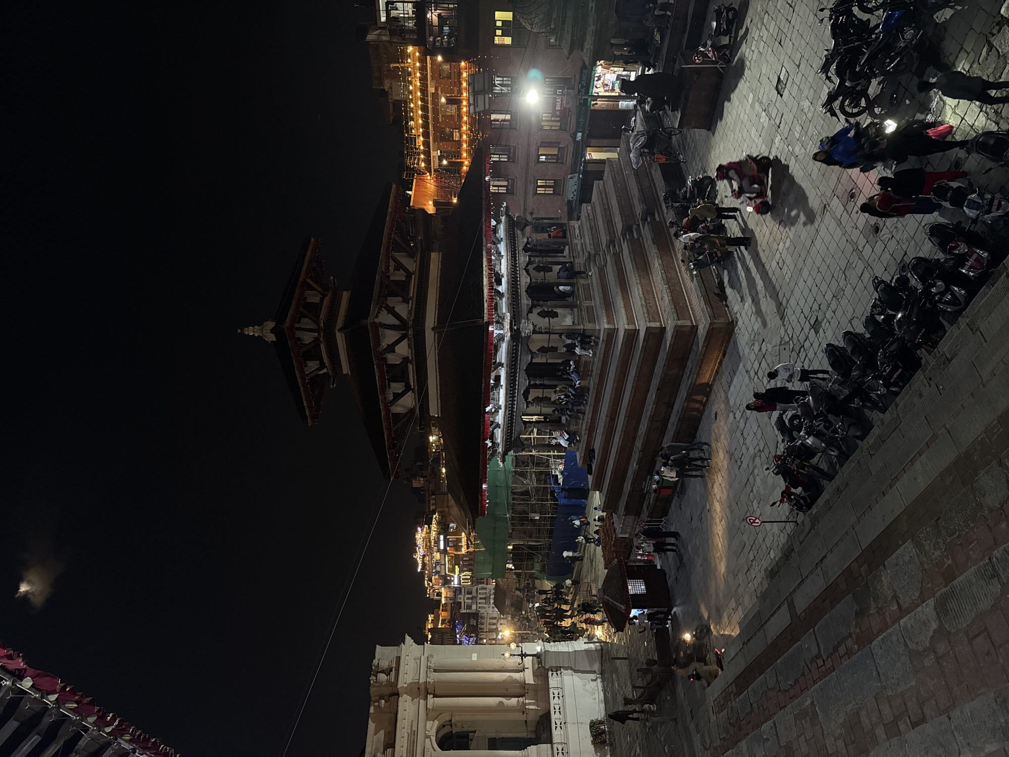 Nighttime activity documented around illuminated pagoda in Kathmandu square