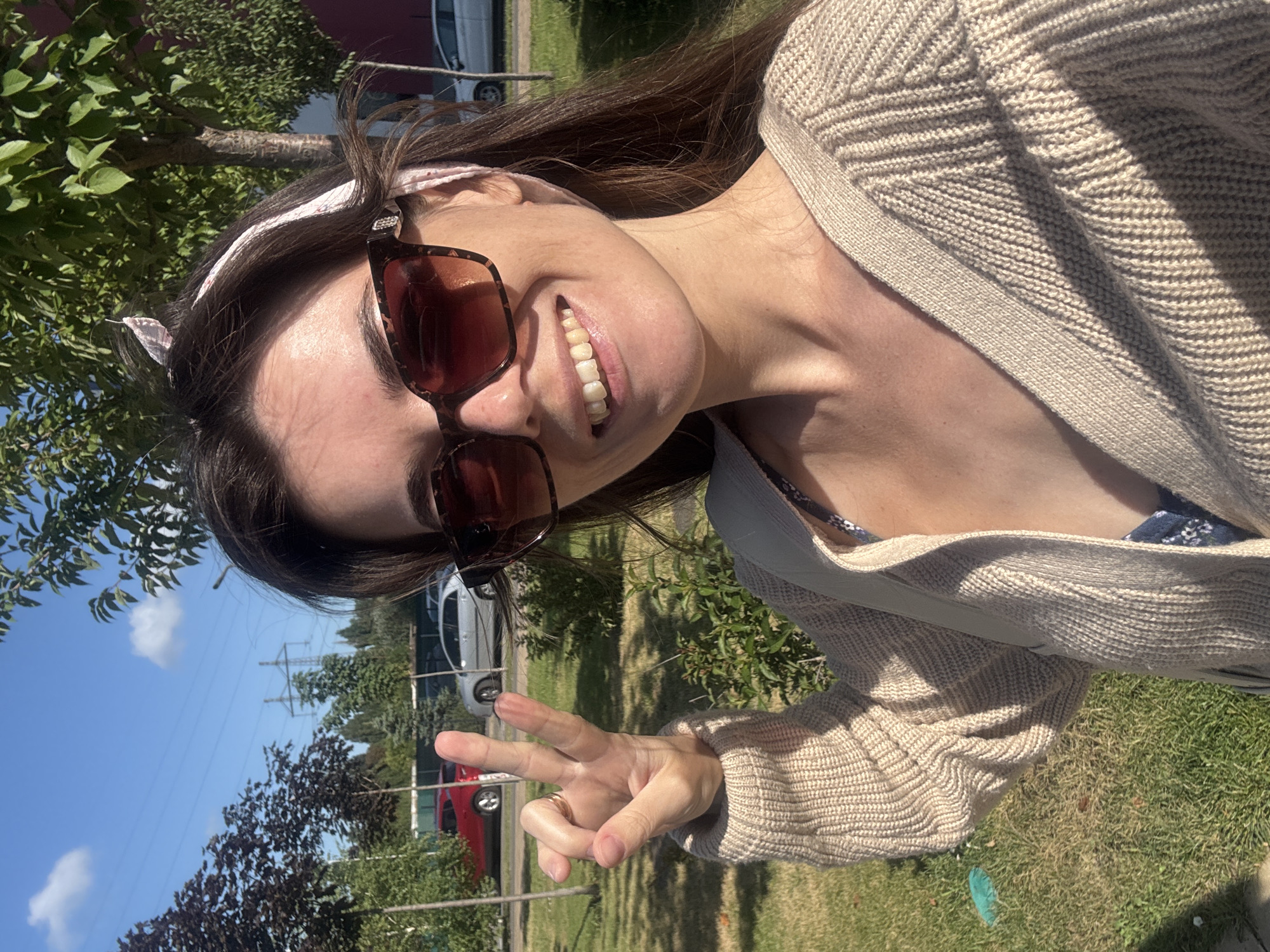 Sunny outdoor selfie with tortoiseshell shades and knit cardigan