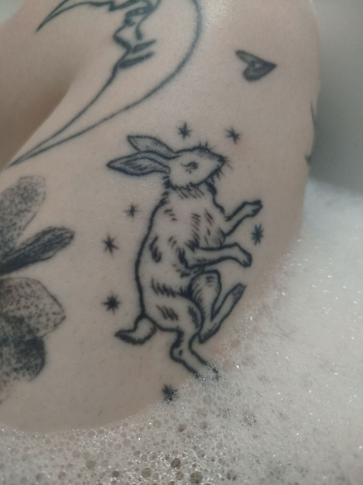 Person with multiple tattoos takes bubble bath