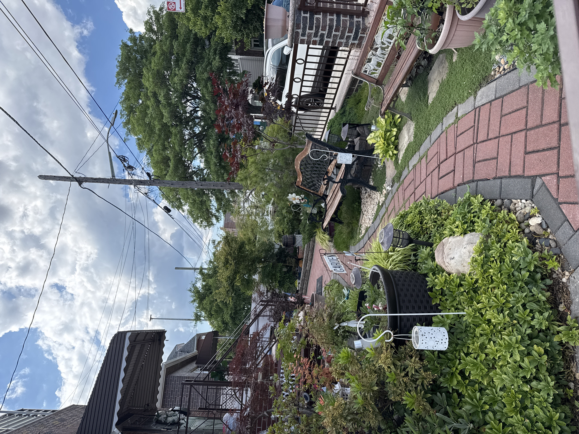 Ornament-packed Queens front garden in full summer bloom