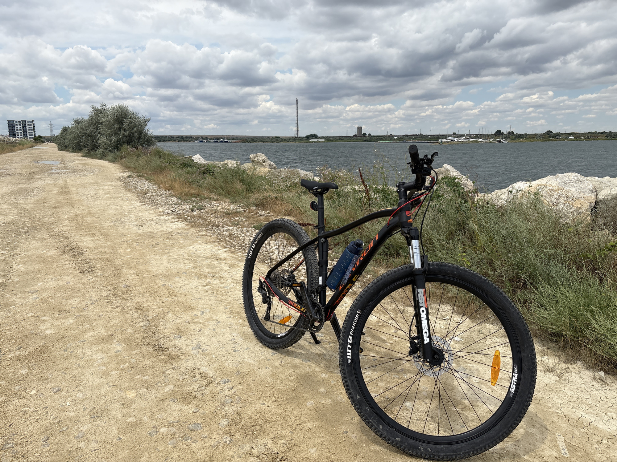 Mountain bike parked on lakeside dirt path, Năvodari