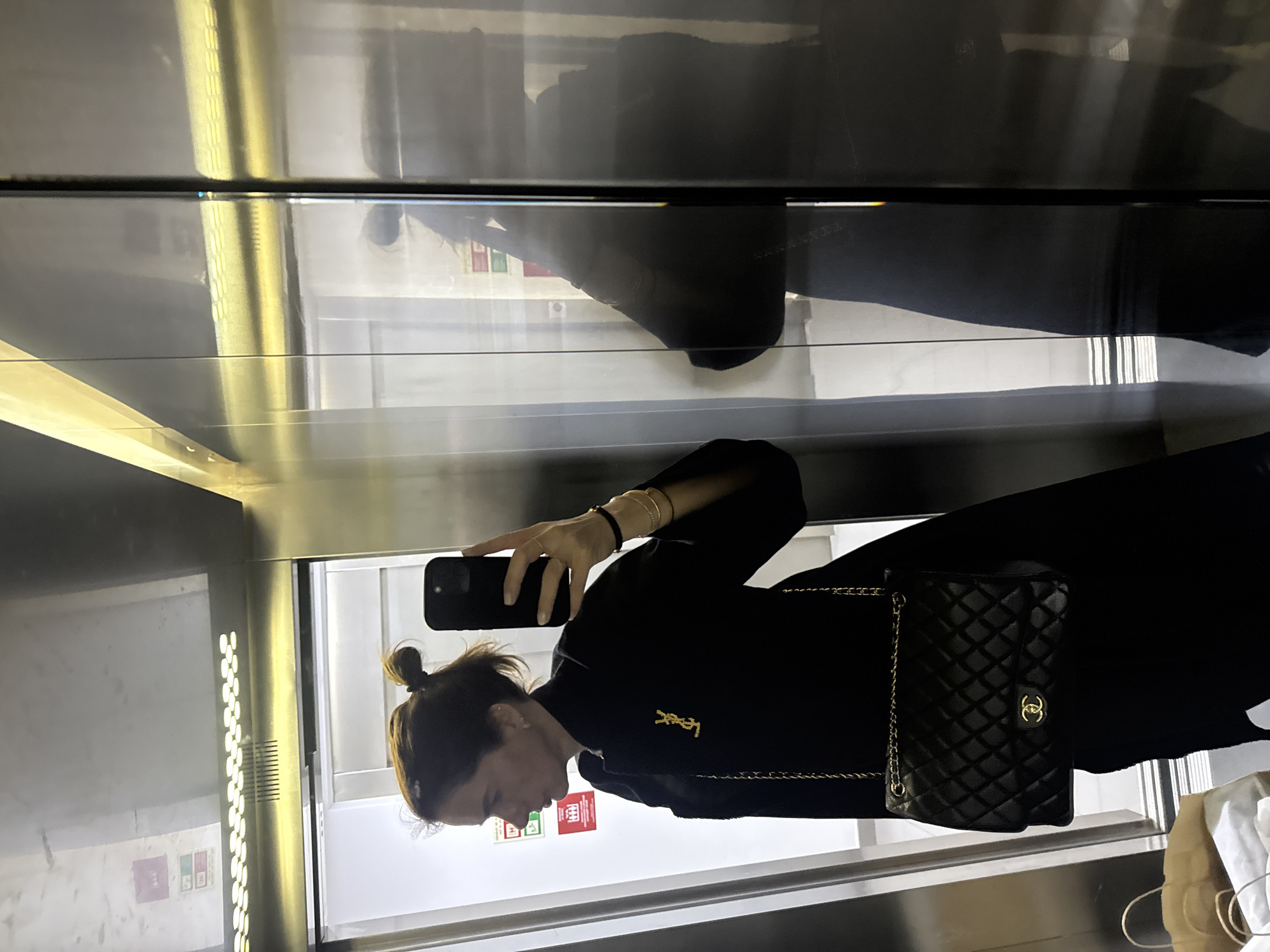 Woman takes elevator selfie in Lisbon wearing black outfit