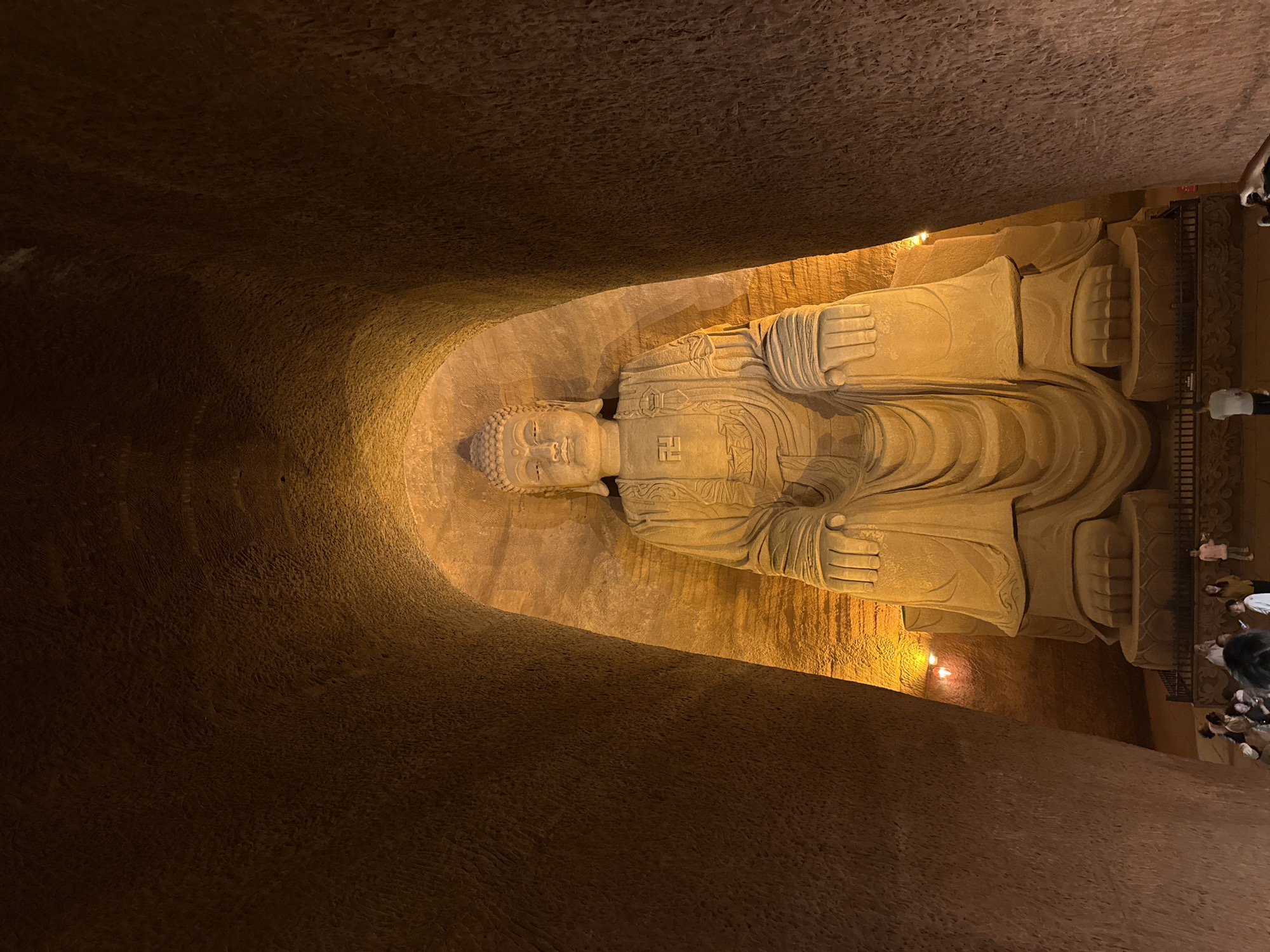 Reclining Buddha statue observed in illuminated cave setting