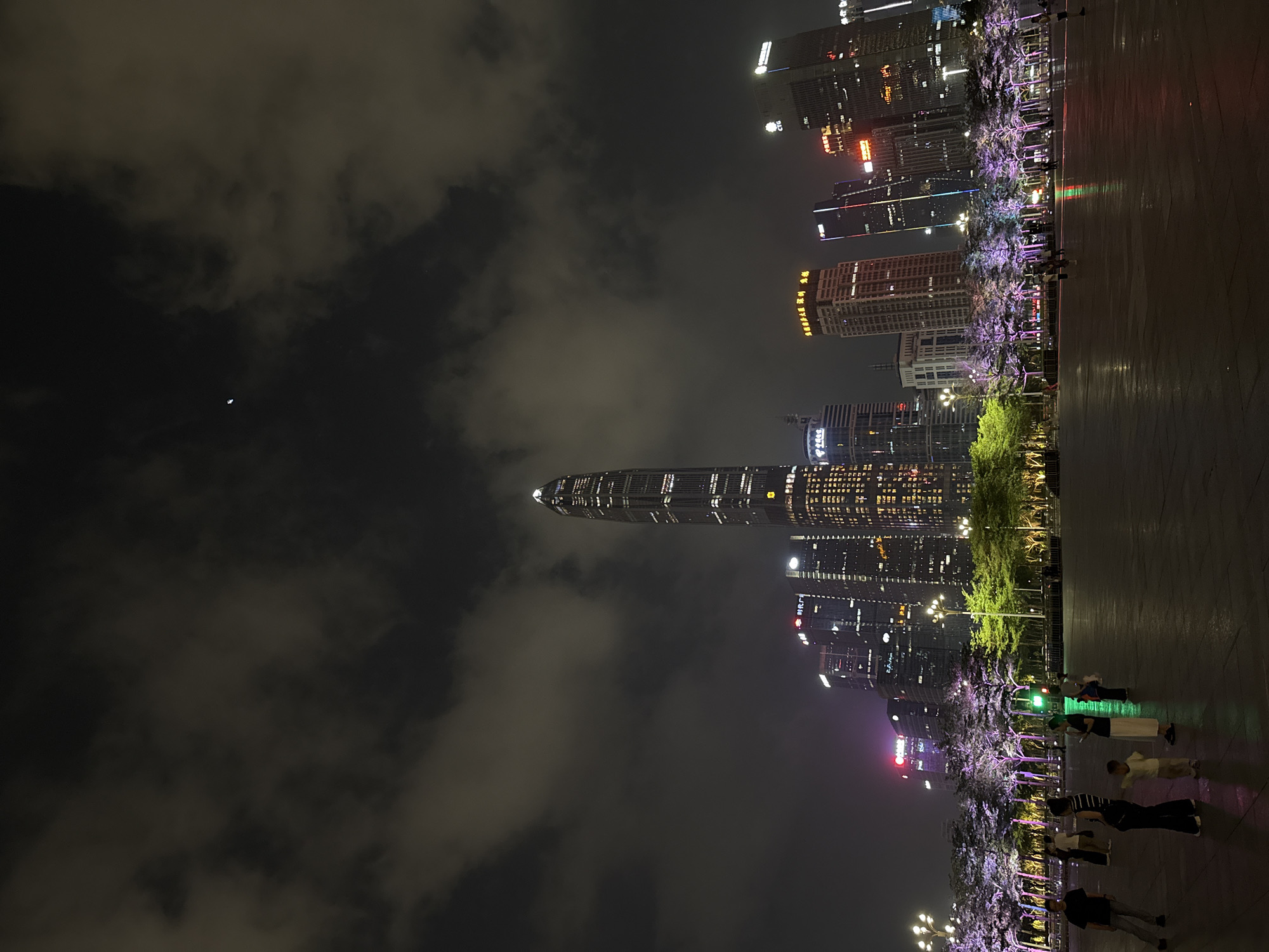 Crowd gathers at illuminated Futian District plaza under crescent moon