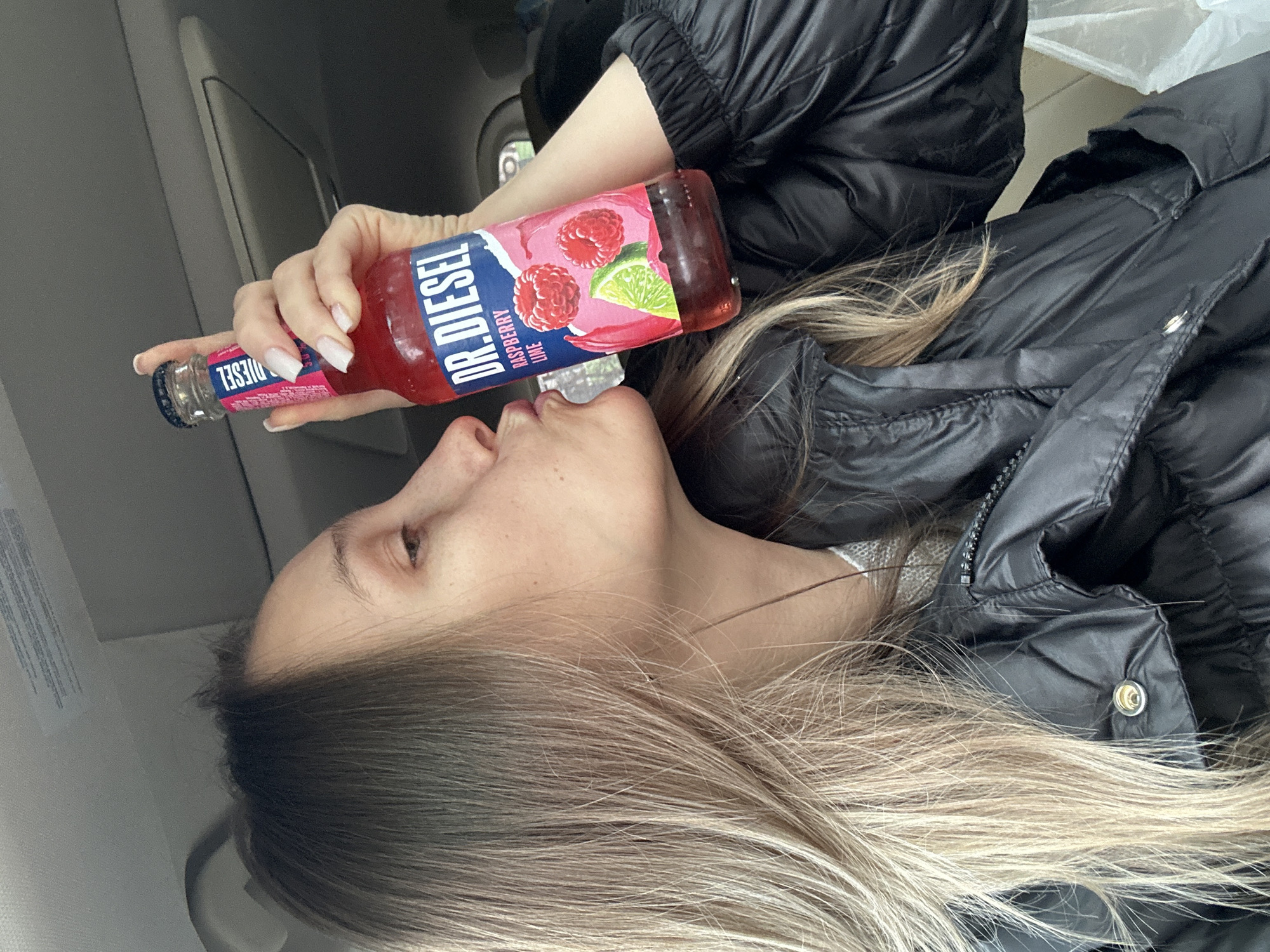 Woman enjoys flavored soda in vehicle in Myskhako