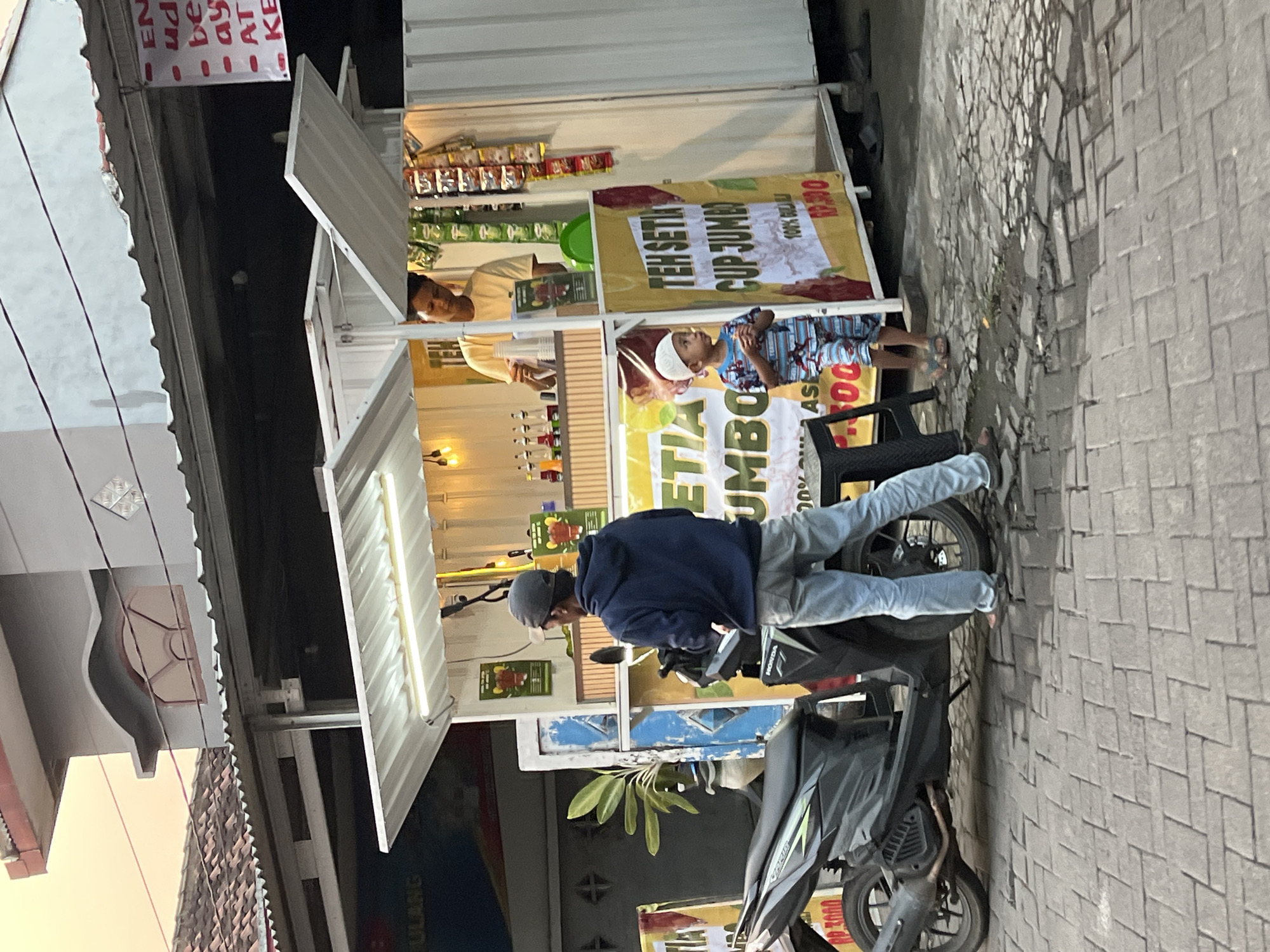 Everyday street life around Kludan's roadside shops and stalls