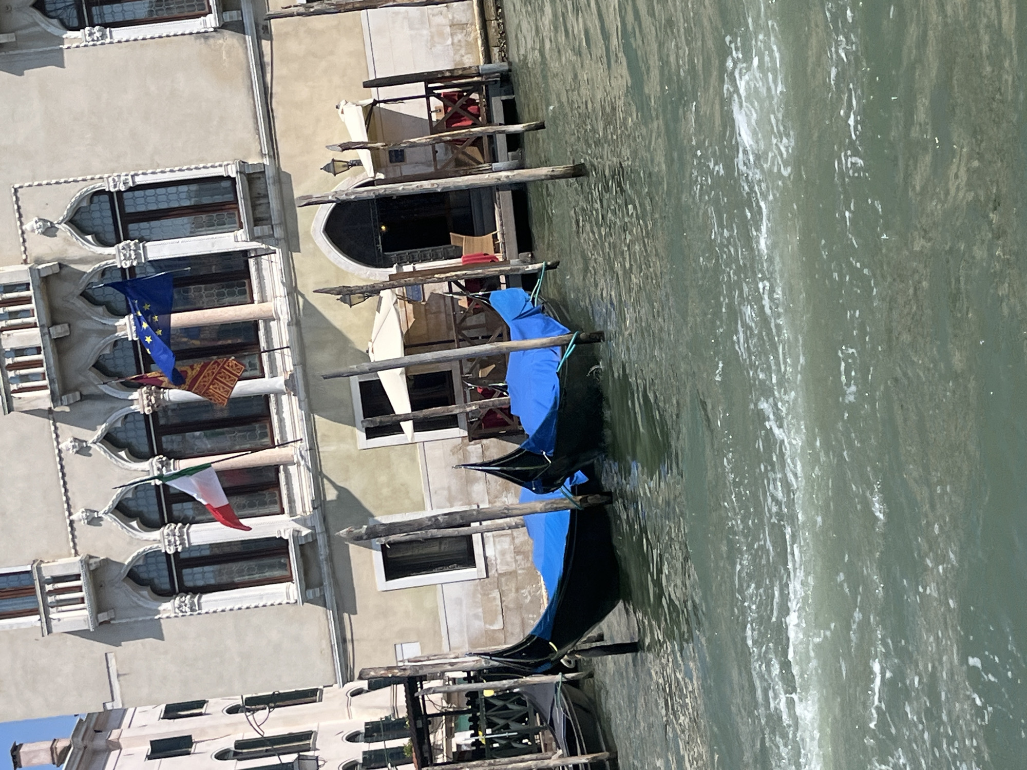 Boats and gondolas along Venice's canals on a clear morning