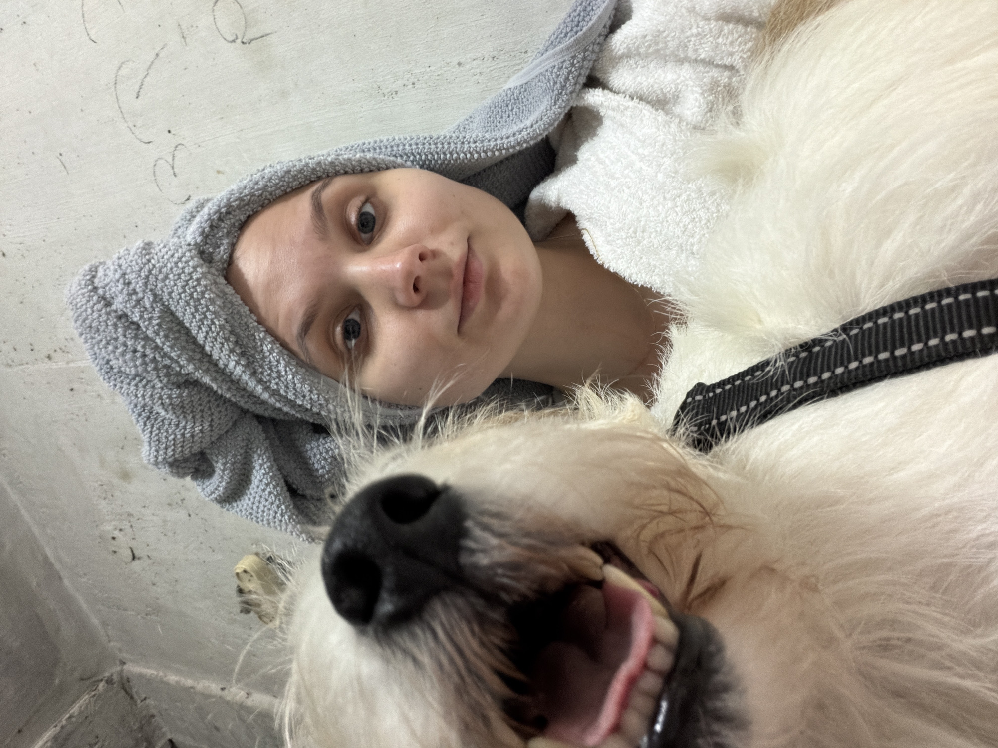 Woman takes selfie with white dog after shower