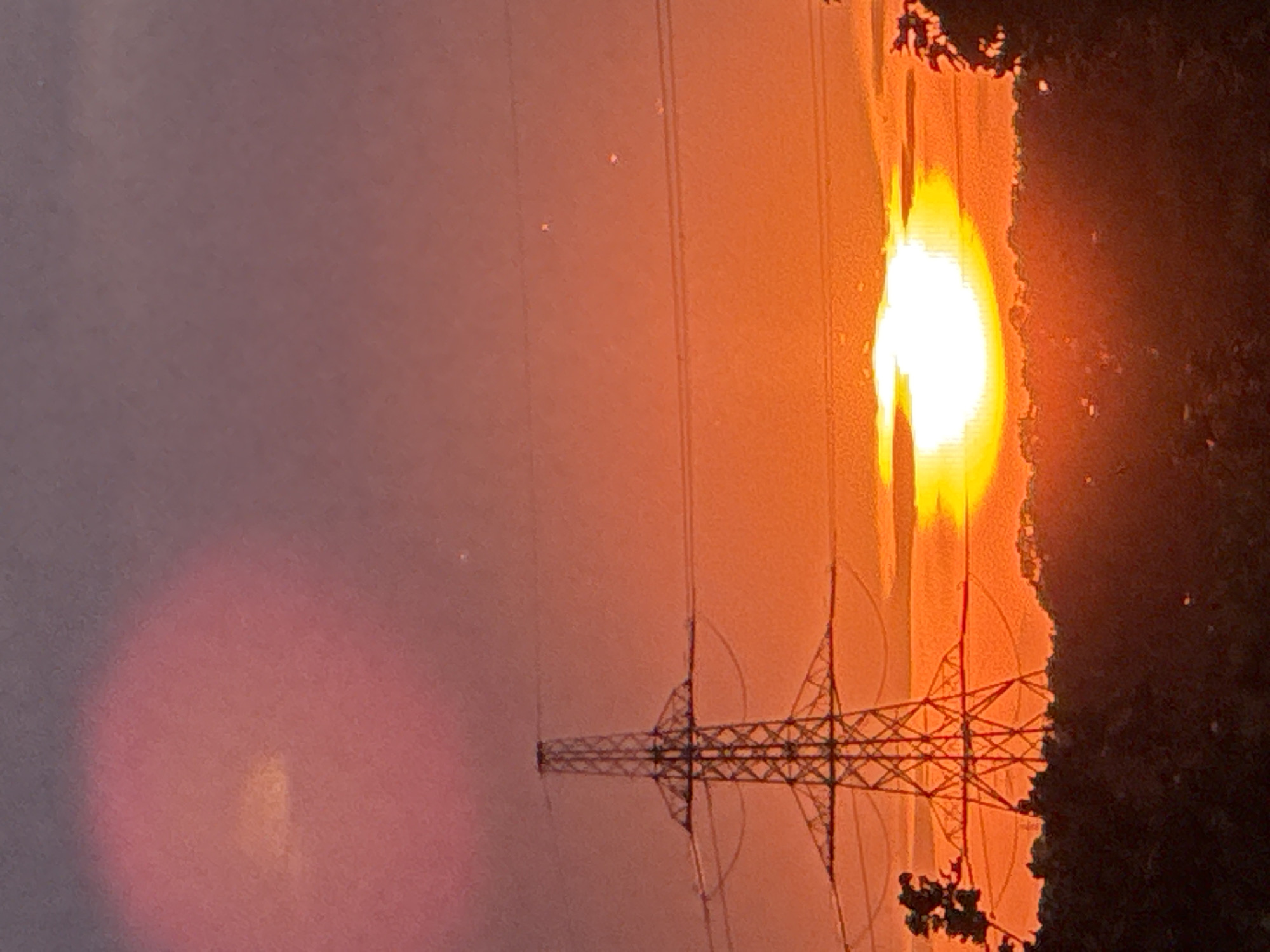 Pylons and power lines silhouetted against a Grays sunset