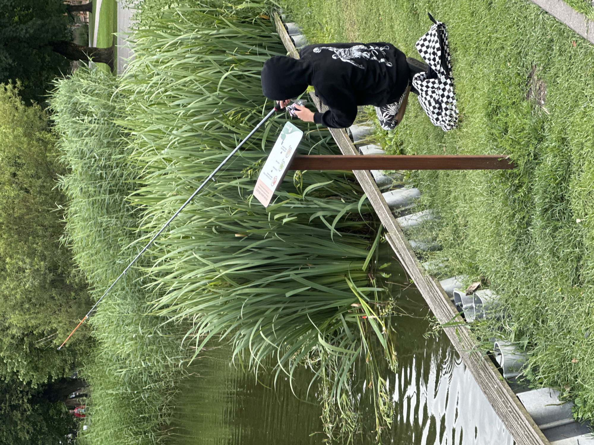 Fishing and ducks along a calm Riga waterway