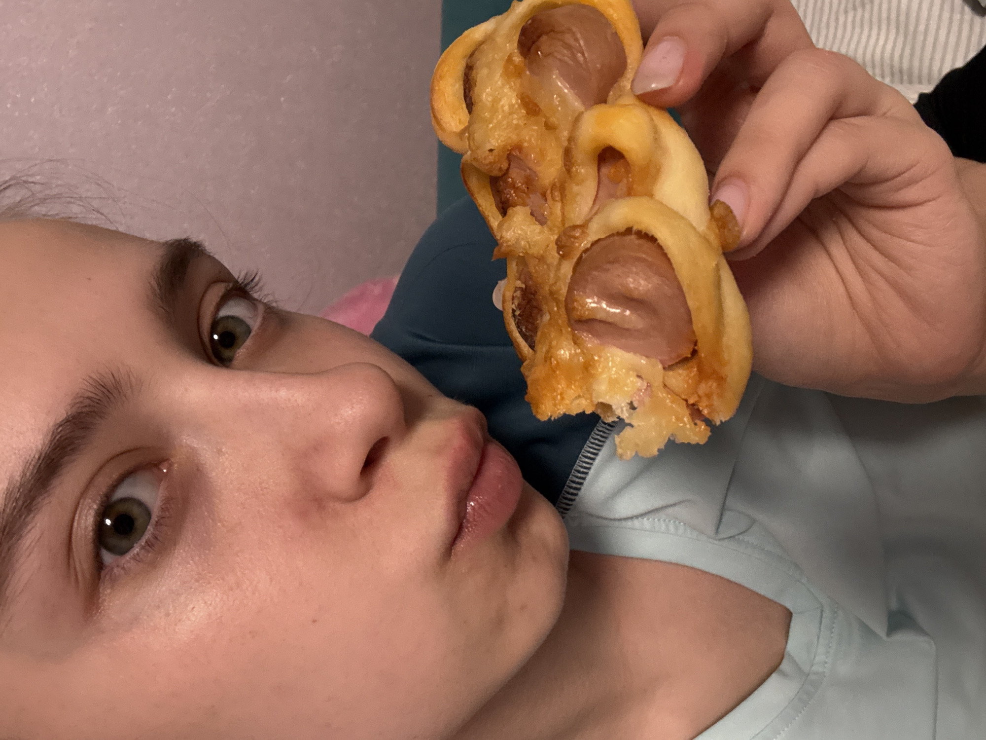 Woman enjoys sausage pastries and fried snacks in Russia