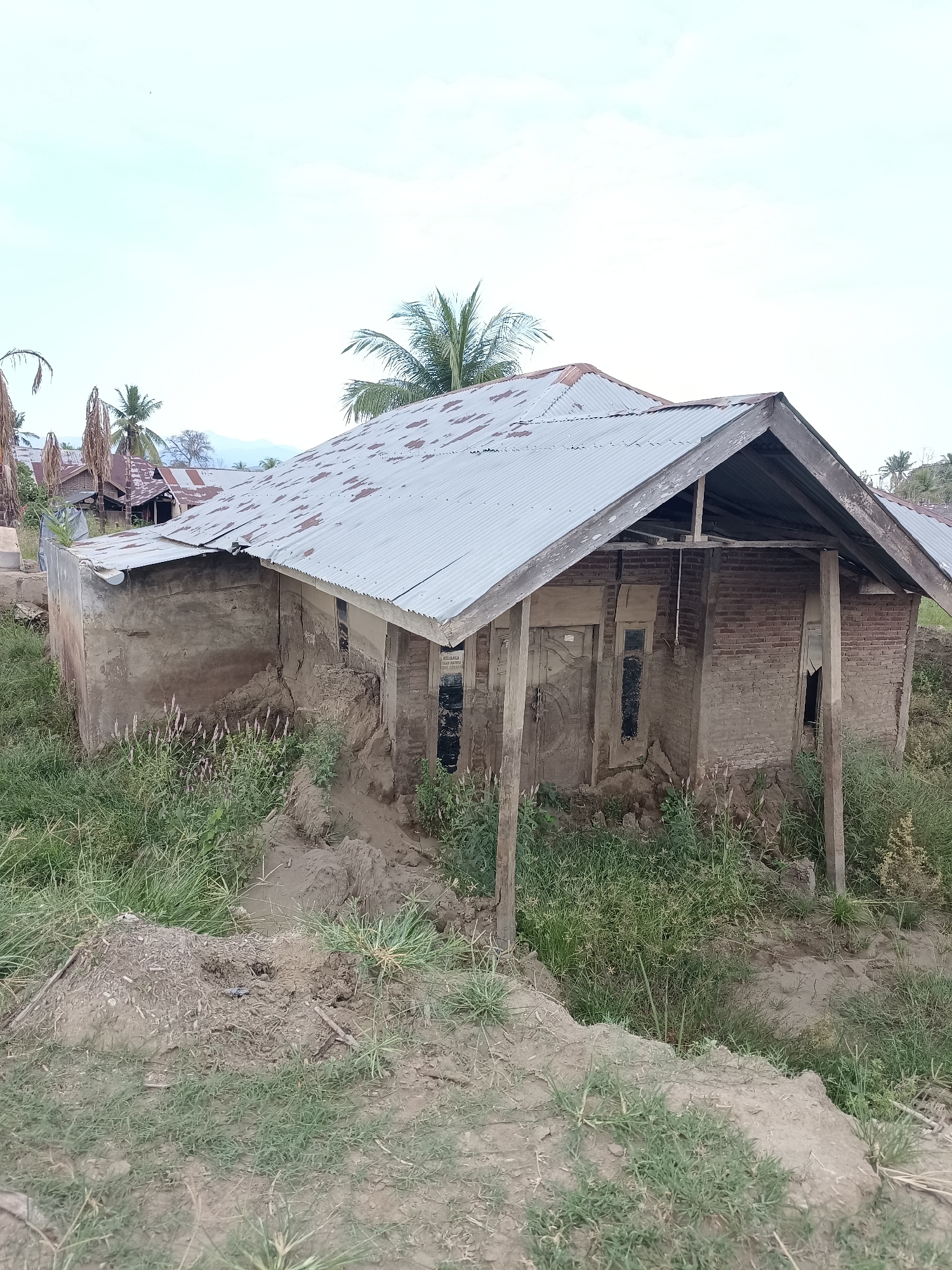 Damaged village structures and disturbed land in rural Aceh