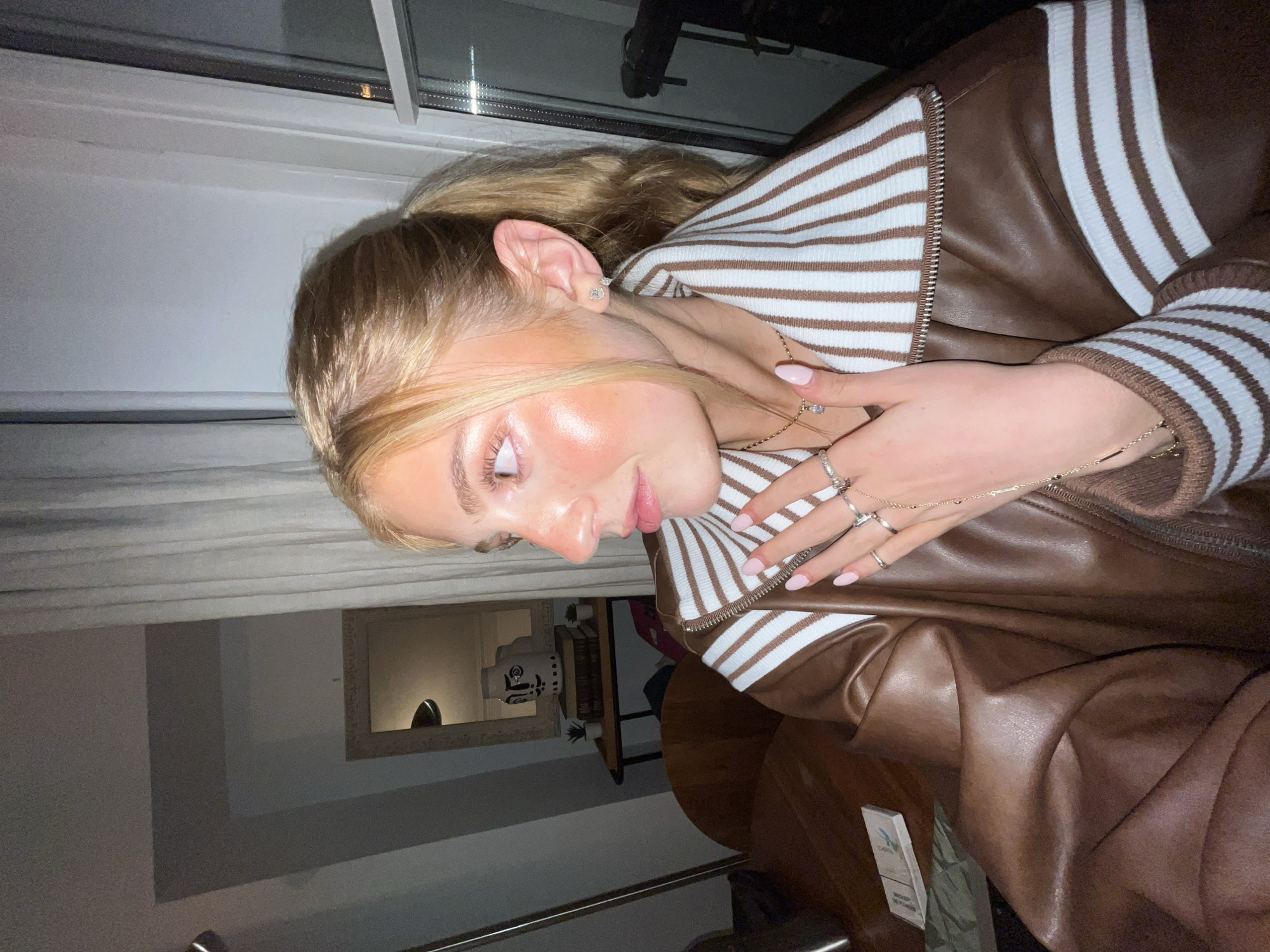 Blonde woman in leather jacket photographed indoors in Paris