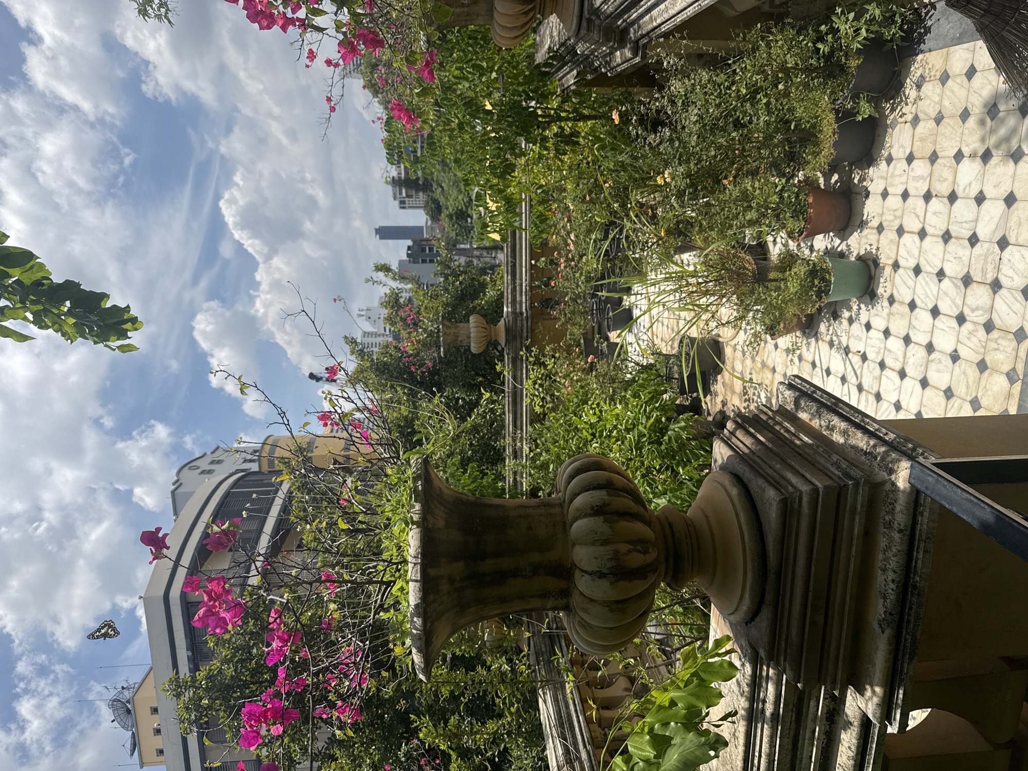 Ornate Bangkok venue with gardens, shrine, and stone walkways