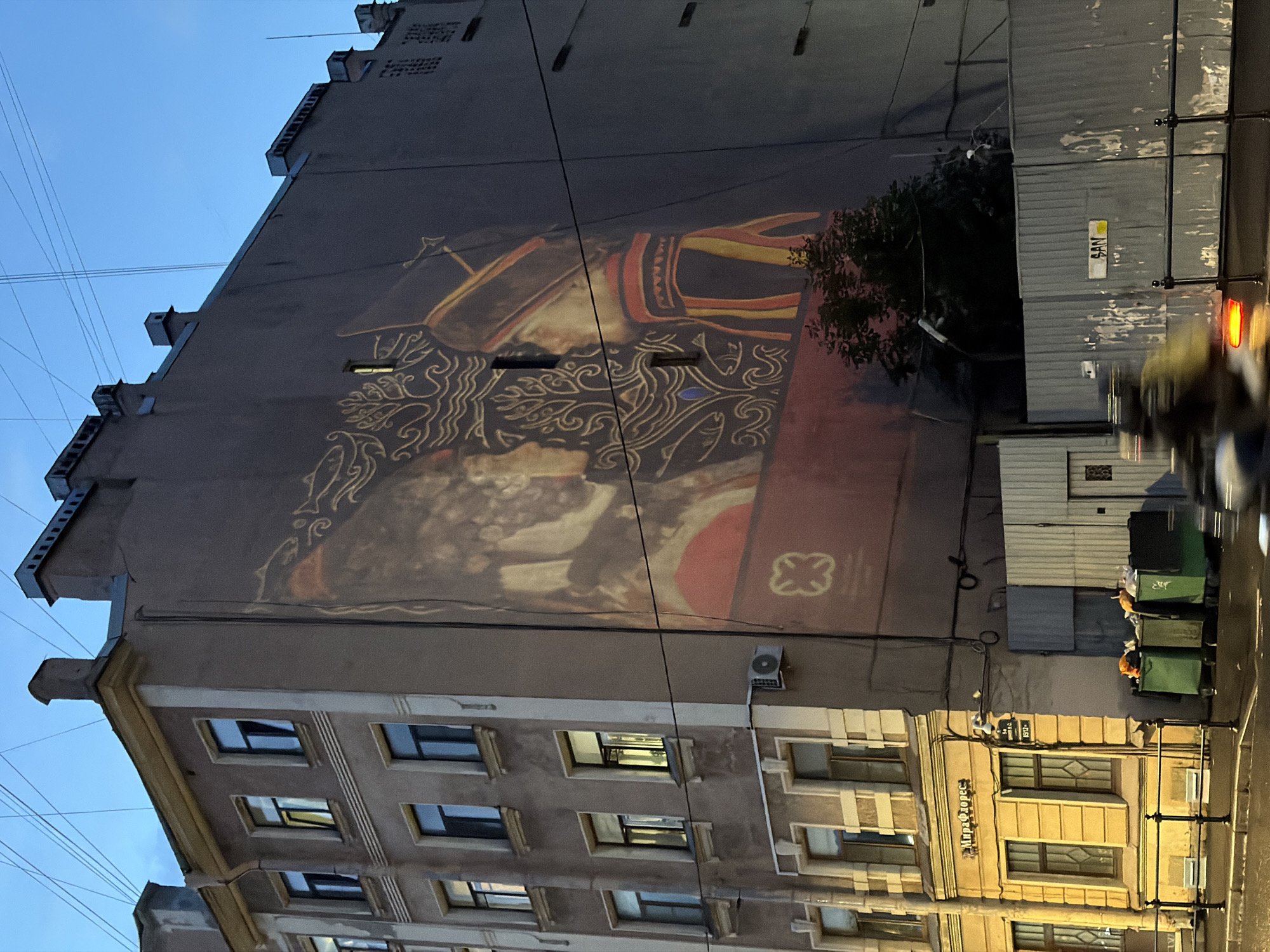 Saint Petersburg streets at dusk, wet asphalt and mural walls