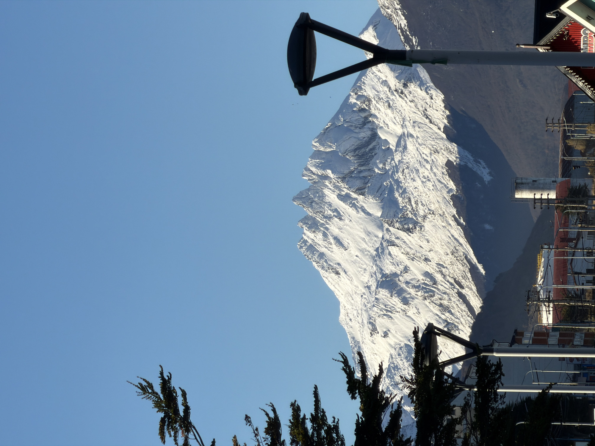 Snow-covered mountain viewed through urban infrastructure in Ushuaia