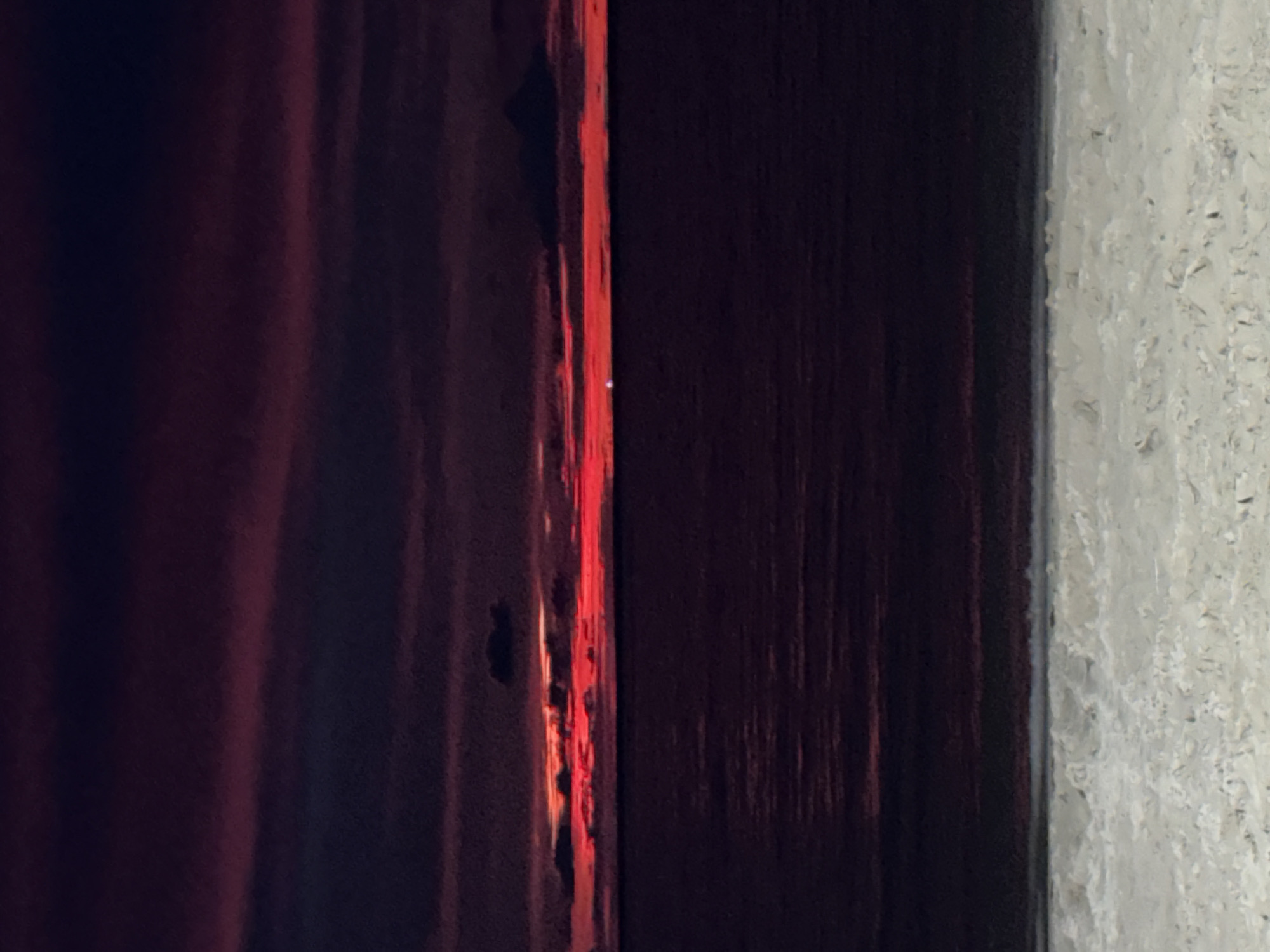 Colorful light captured between wooden frame and wall in Patong
