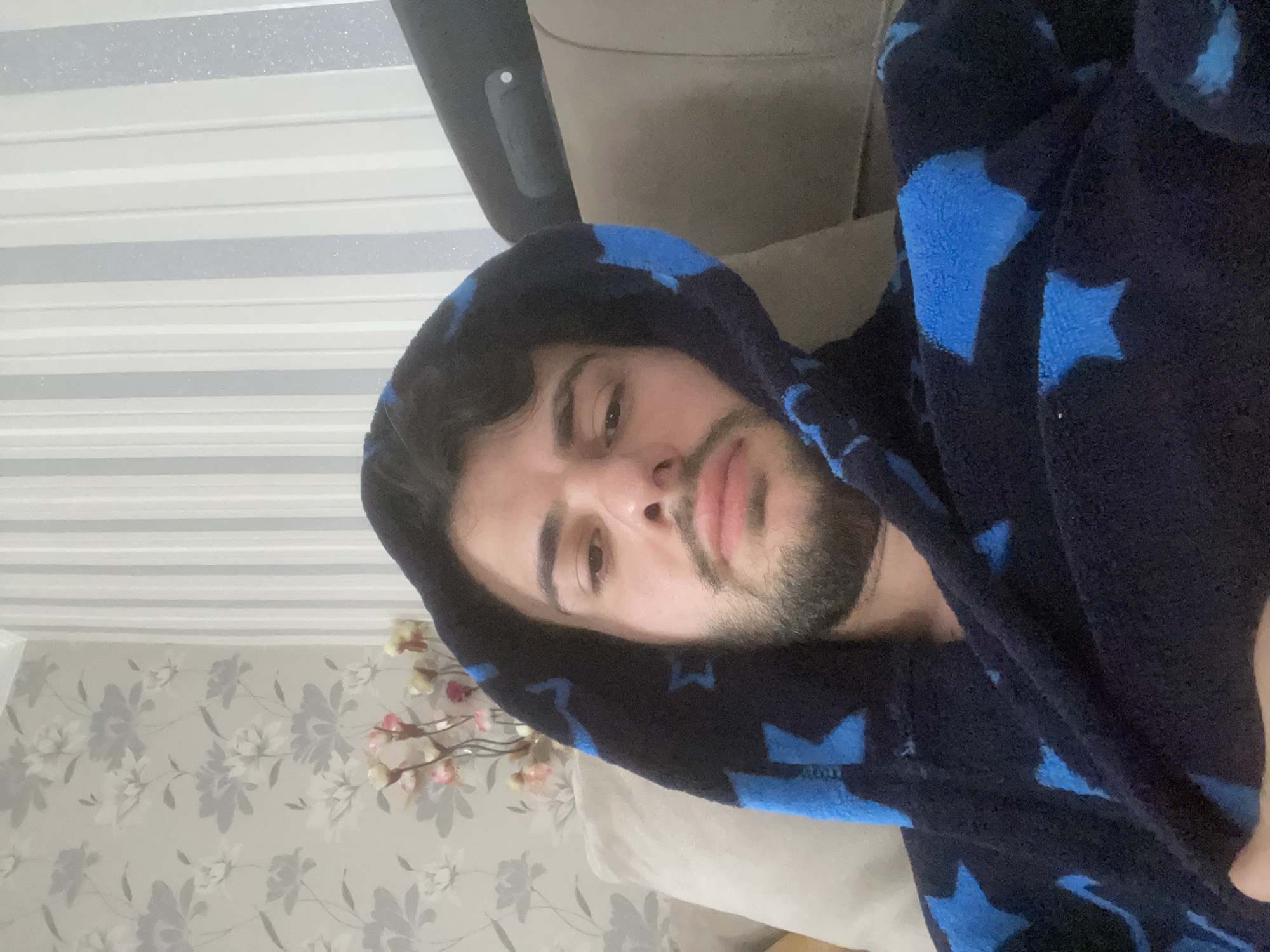 Man in star-patterned robe relaxes on couch in Tbilisi