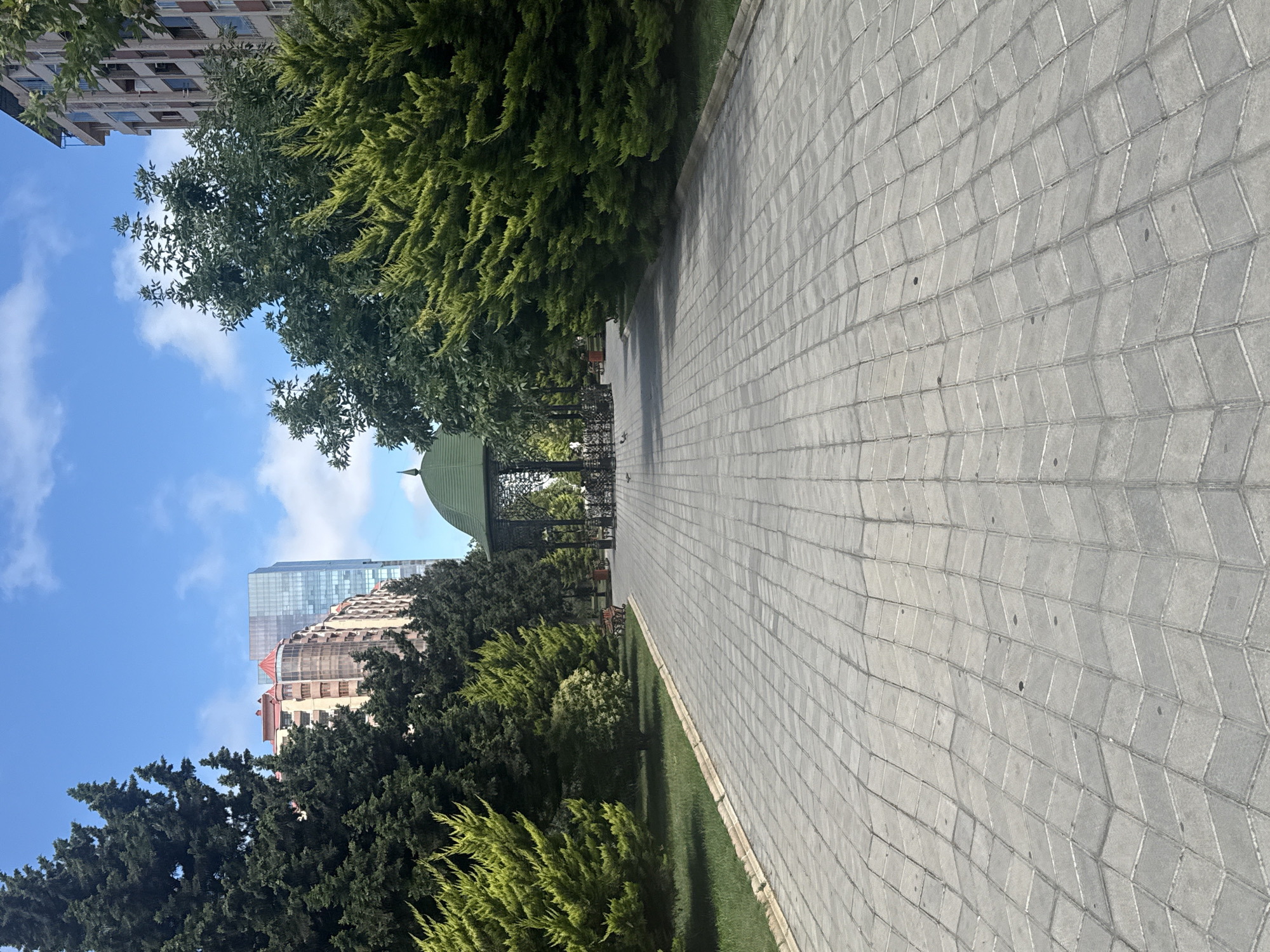 Chevron-paved park path leads to a gazebo in Khatay Raion