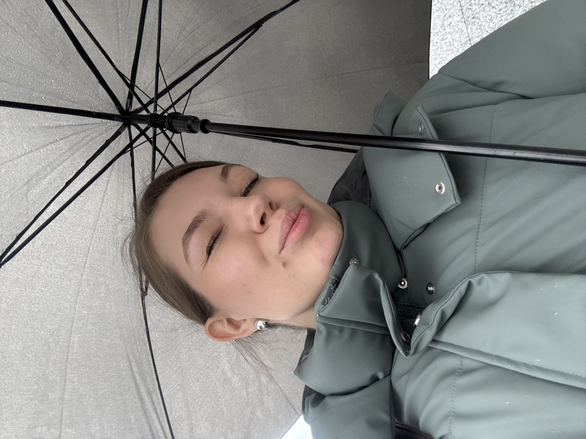 Woman shelters under umbrella during rainy morning in Belgrade