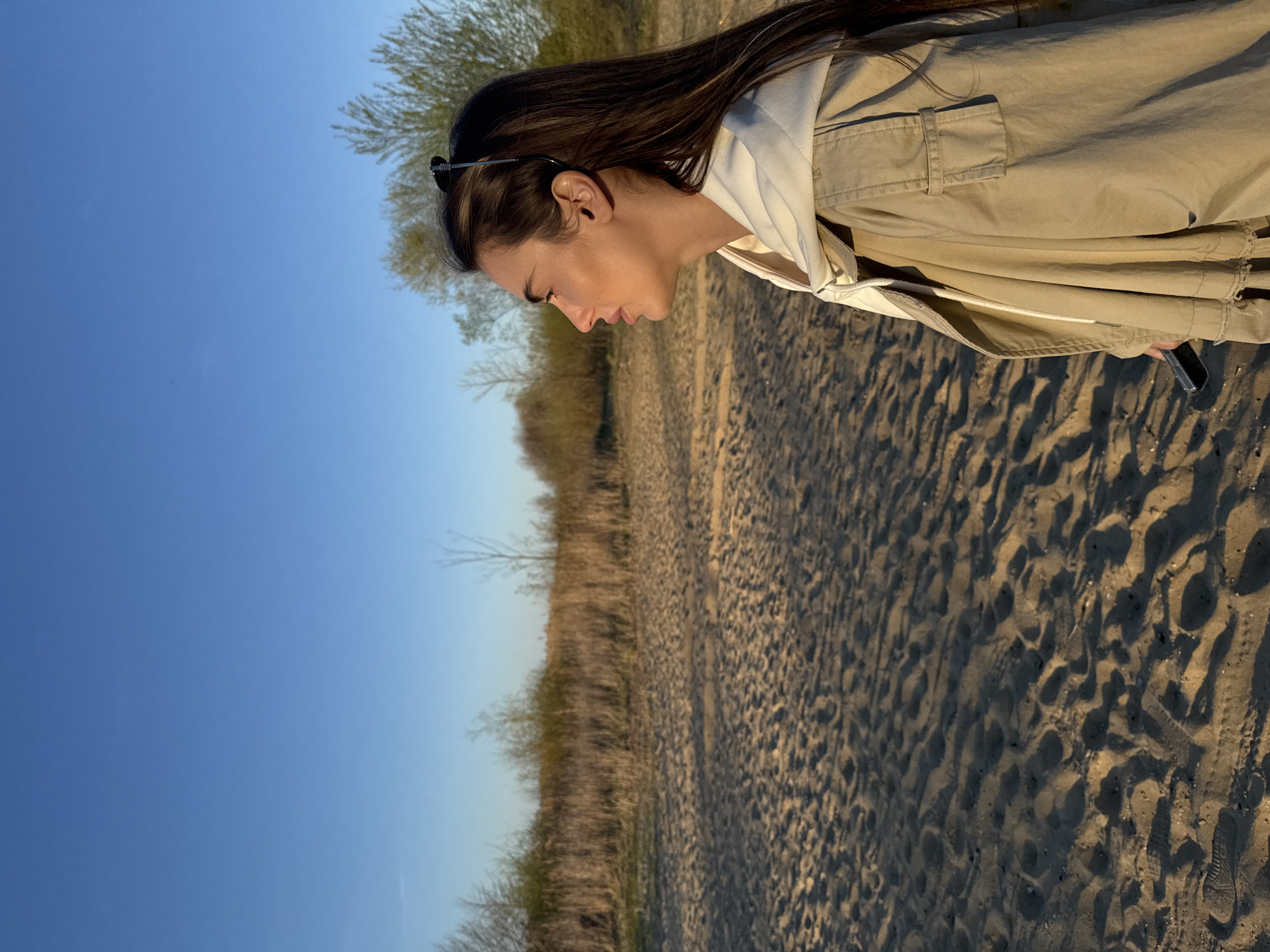 Woman watches sunset at lake in Arciechów, Poland
