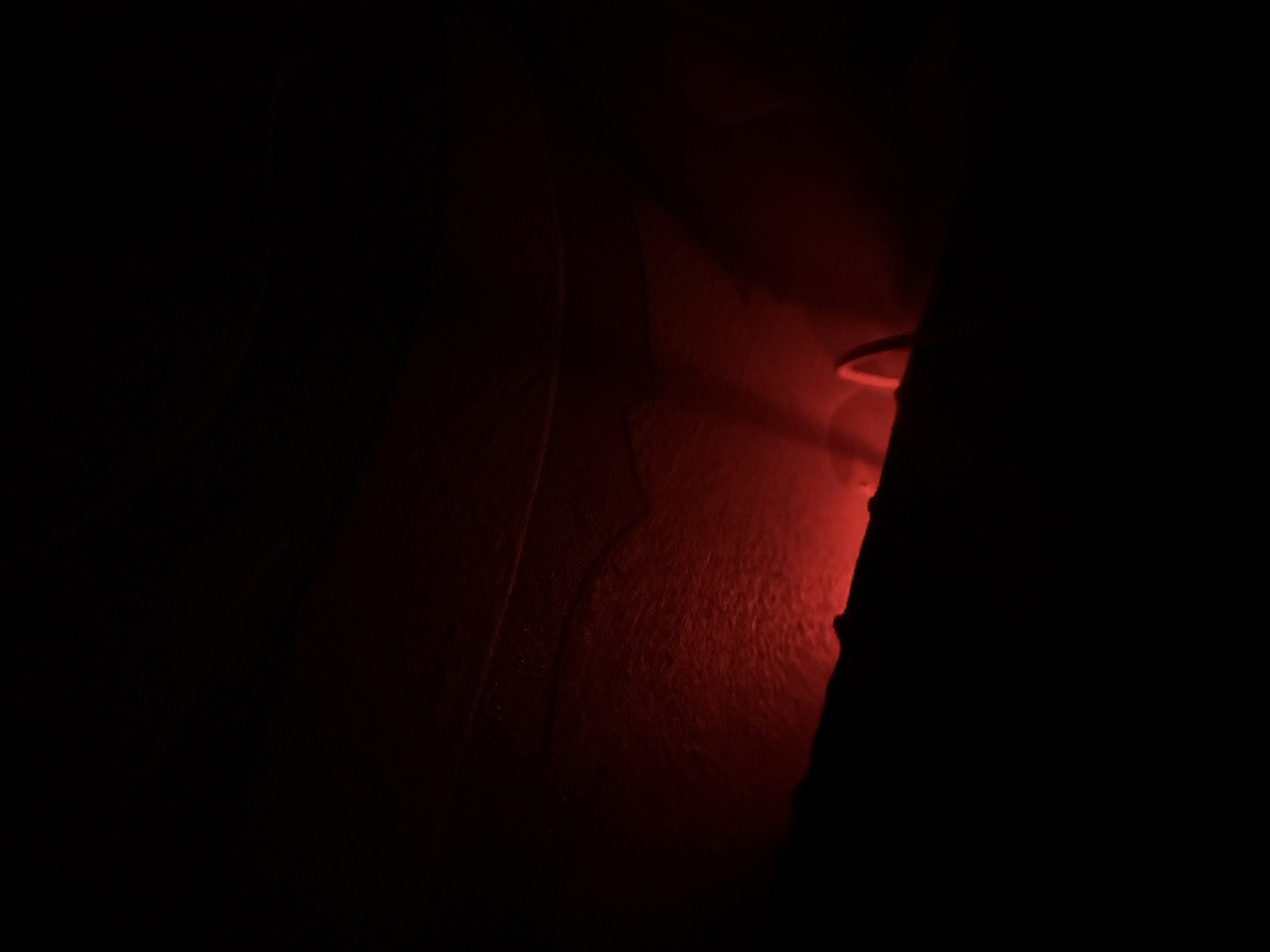 Hand captured in mysterious red-lit dark environment