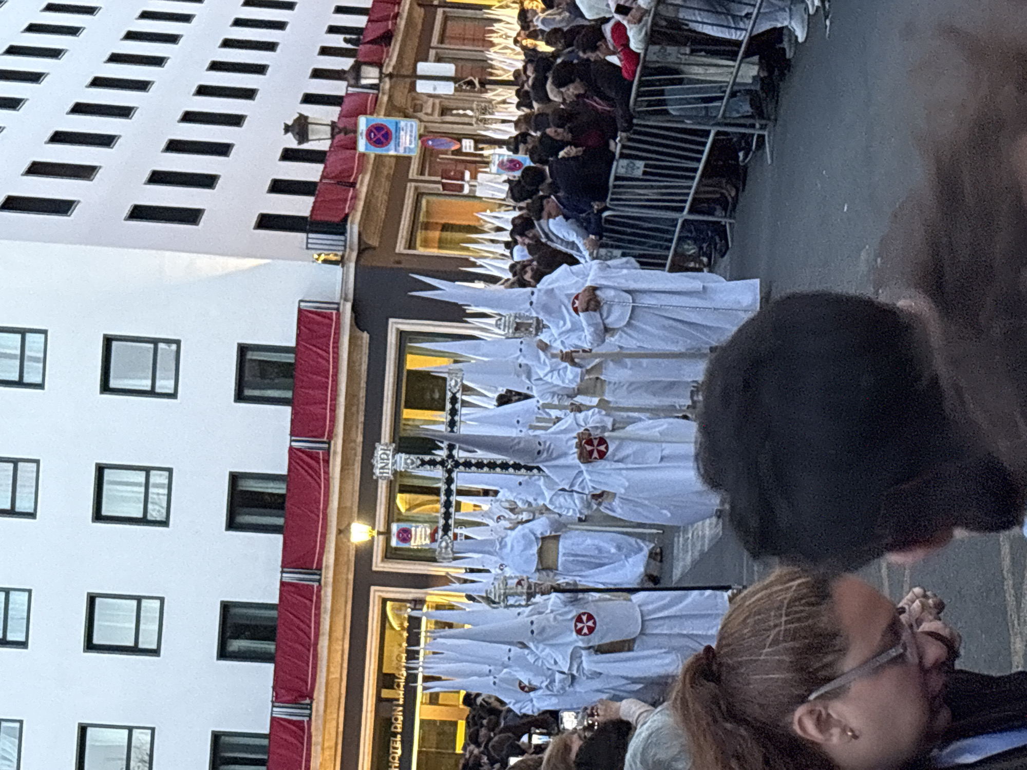 Religious procession with robed participants observed in Seville