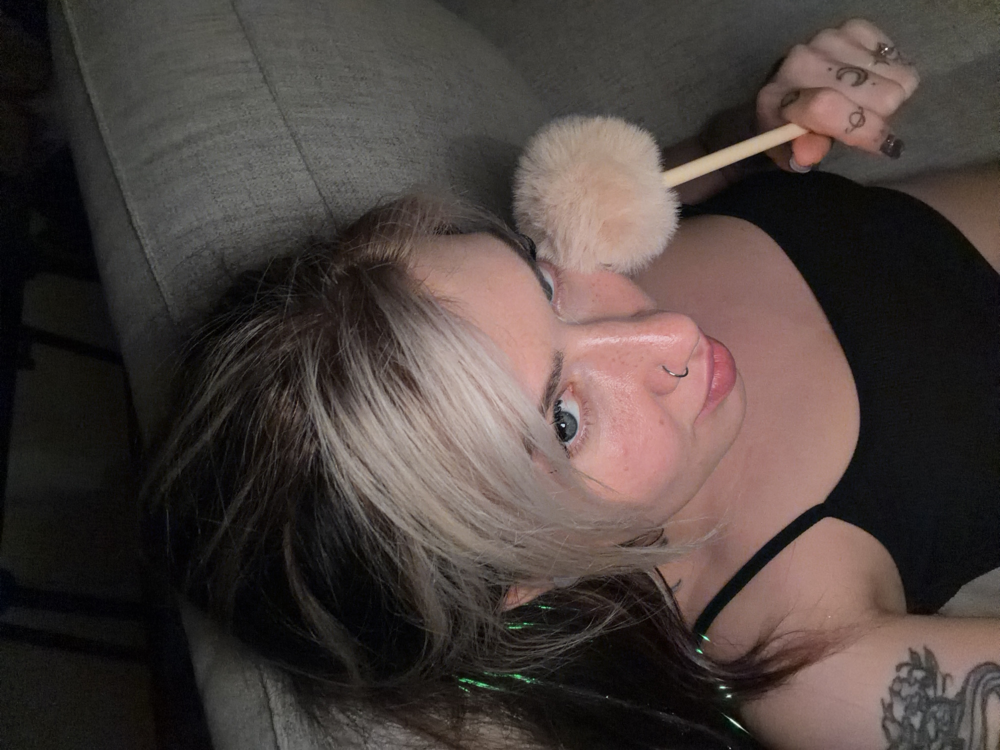 Woman applies makeup while gaming on couch in Budva
