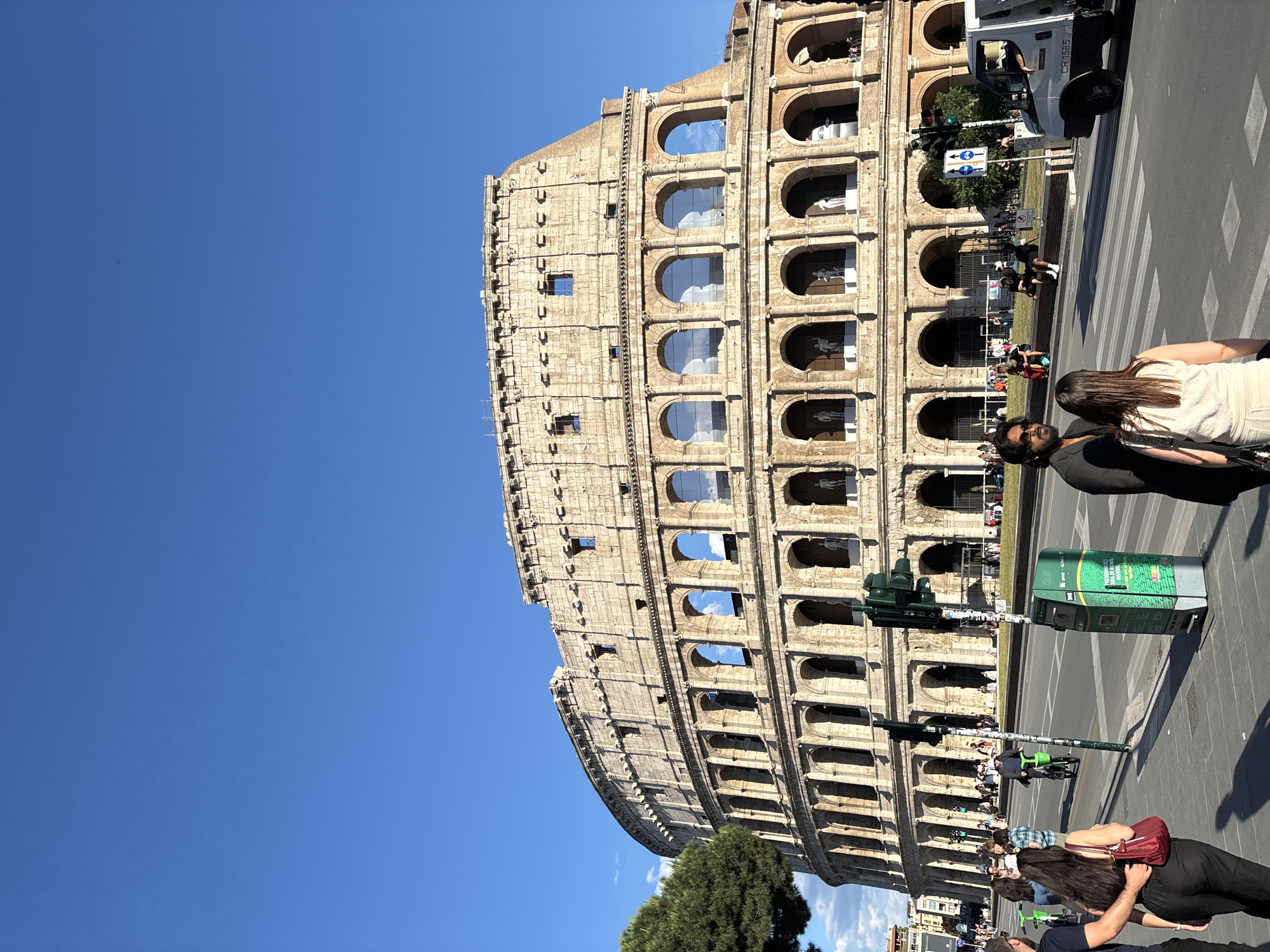 Clear skies frame Rome's Colosseum as tourists gather