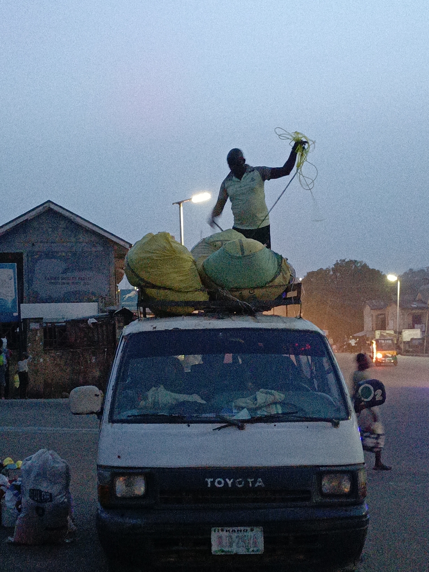 Man secures cargo atop loaded Toyota van