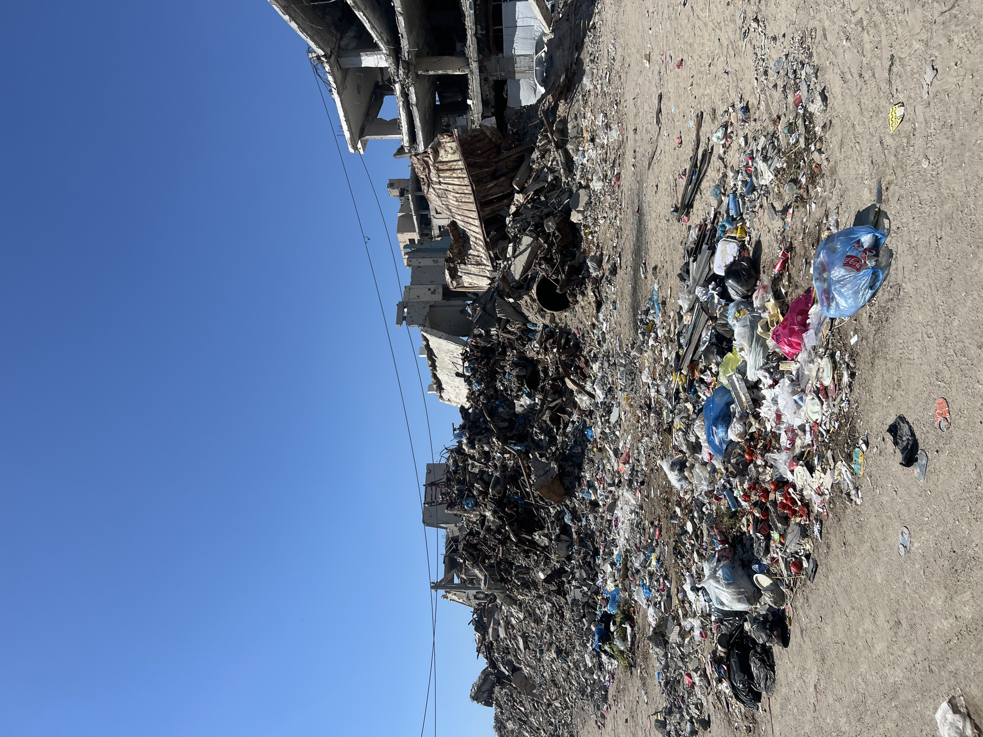 Street-level destruction across a damaged Gaza neighborhood
