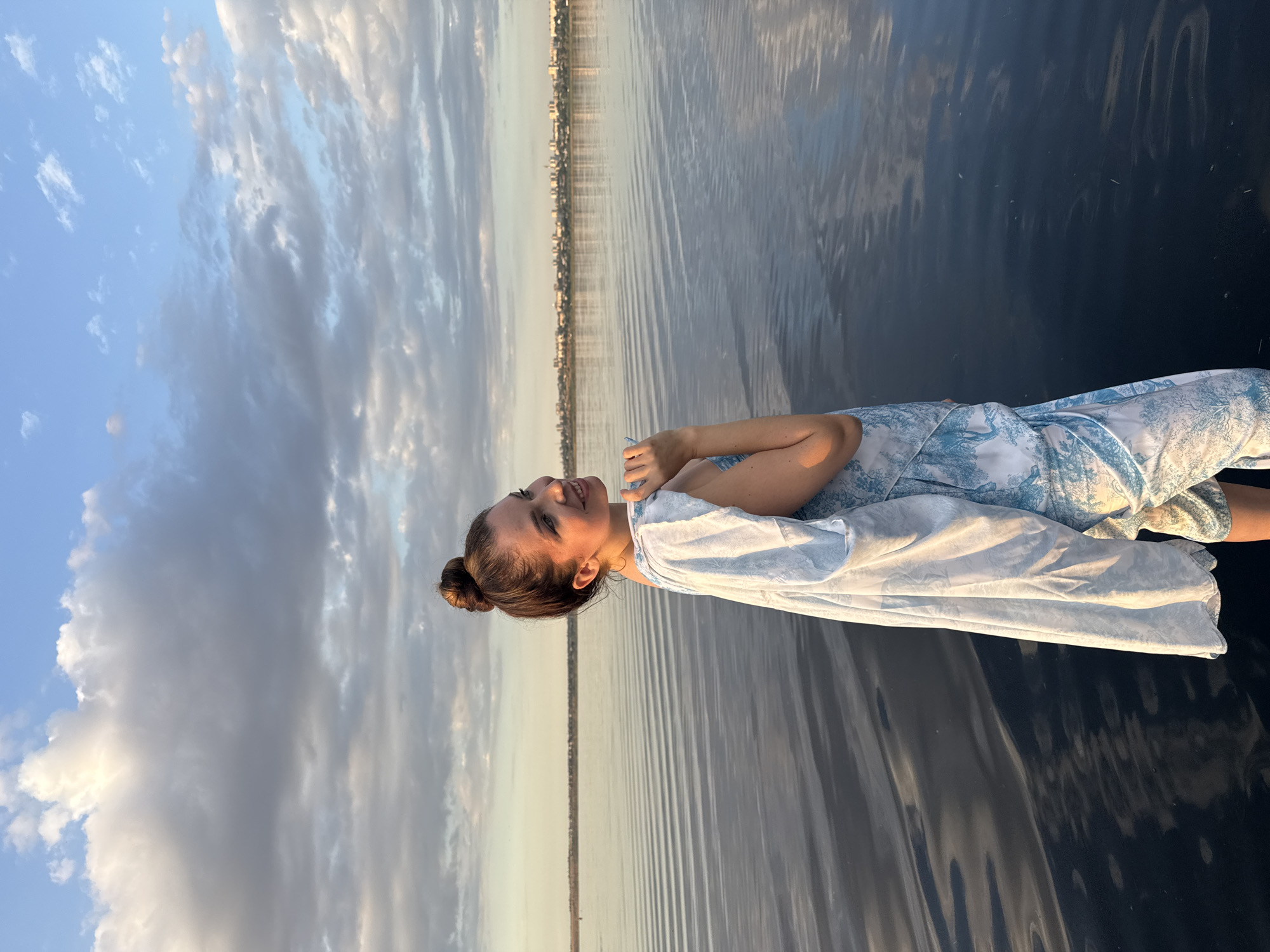 Floating in dress, Odesa waterfront, city skyline behind