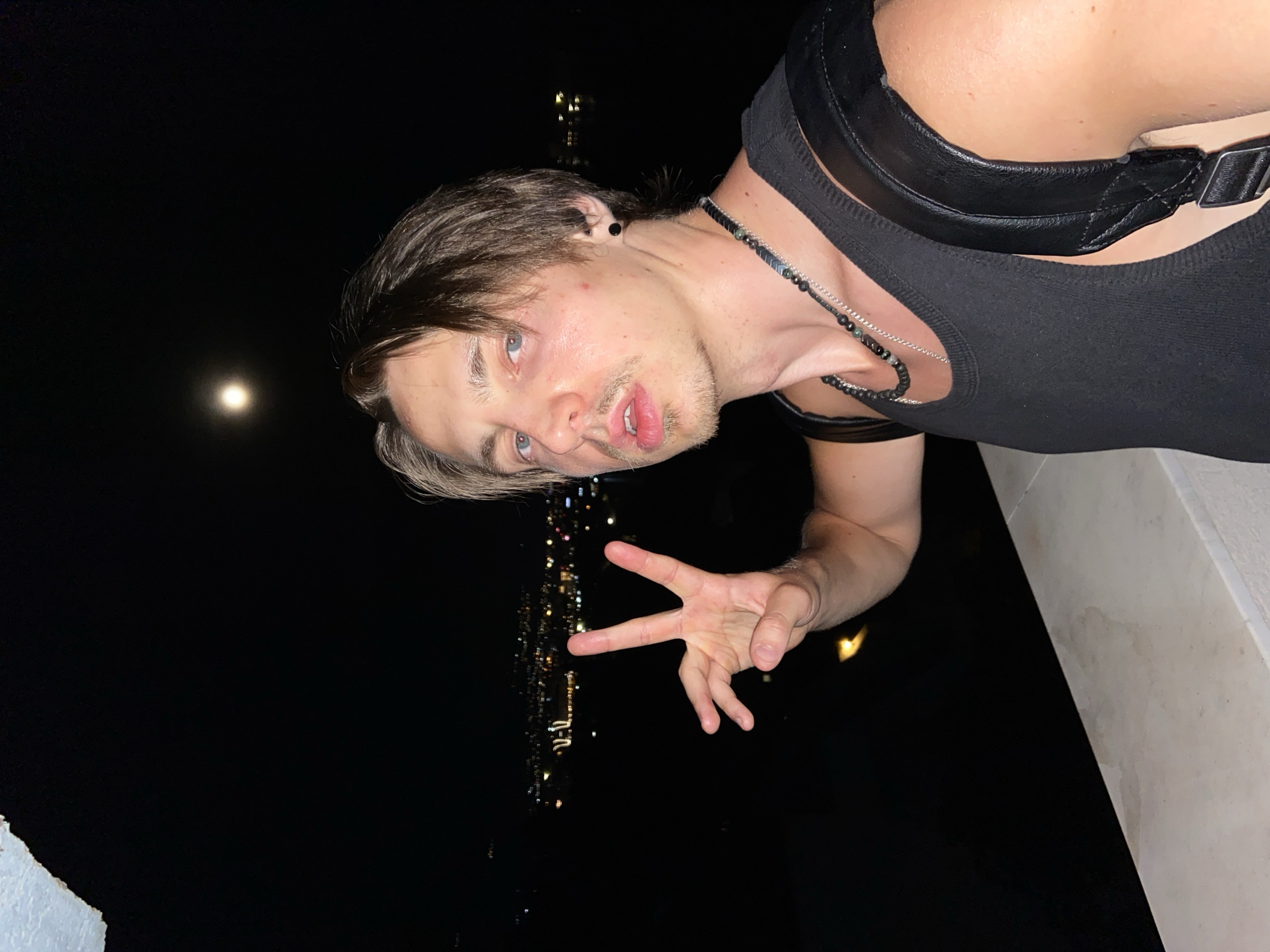 Young man poses on ledge during moonlit night in Šušanj