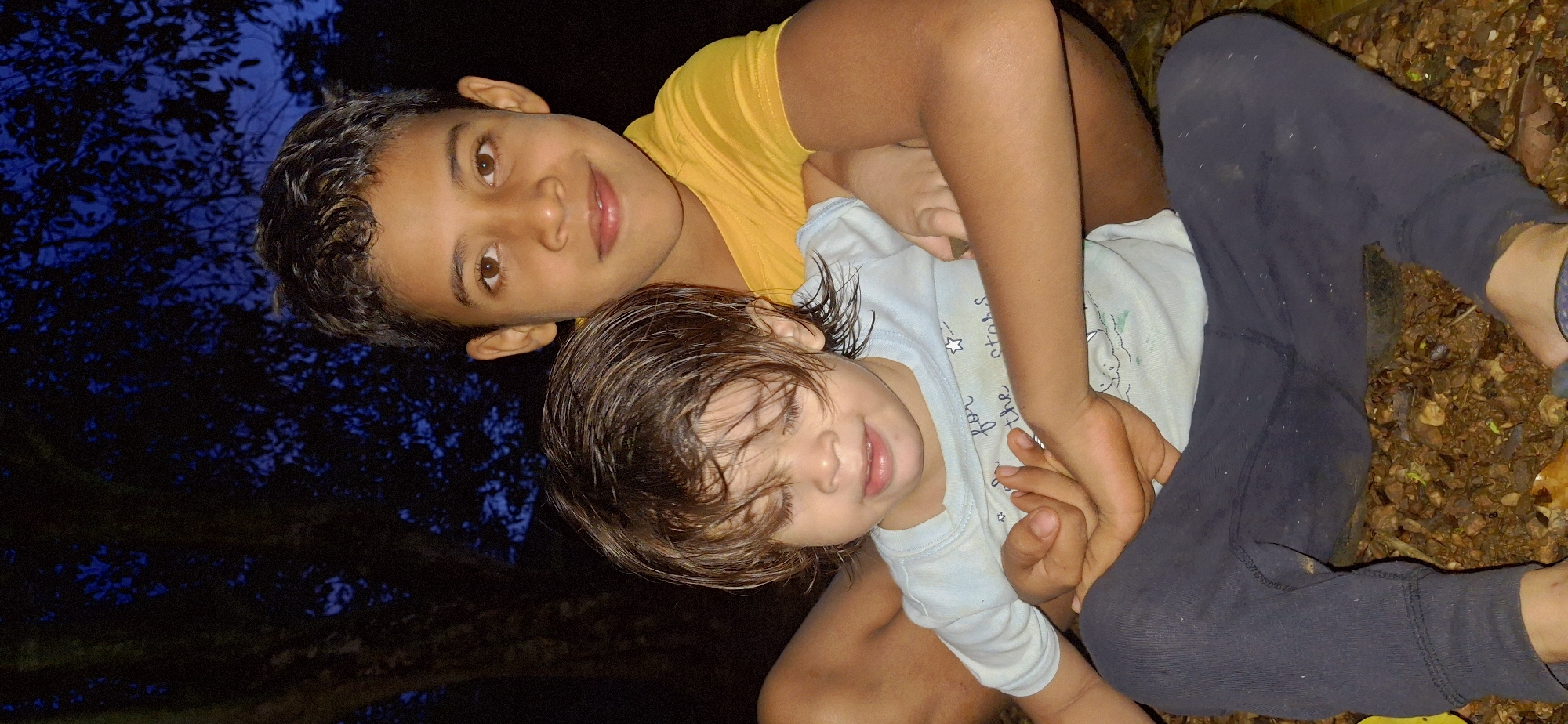 Backyard evening in rural Vallecito: kids, plants, and night falling