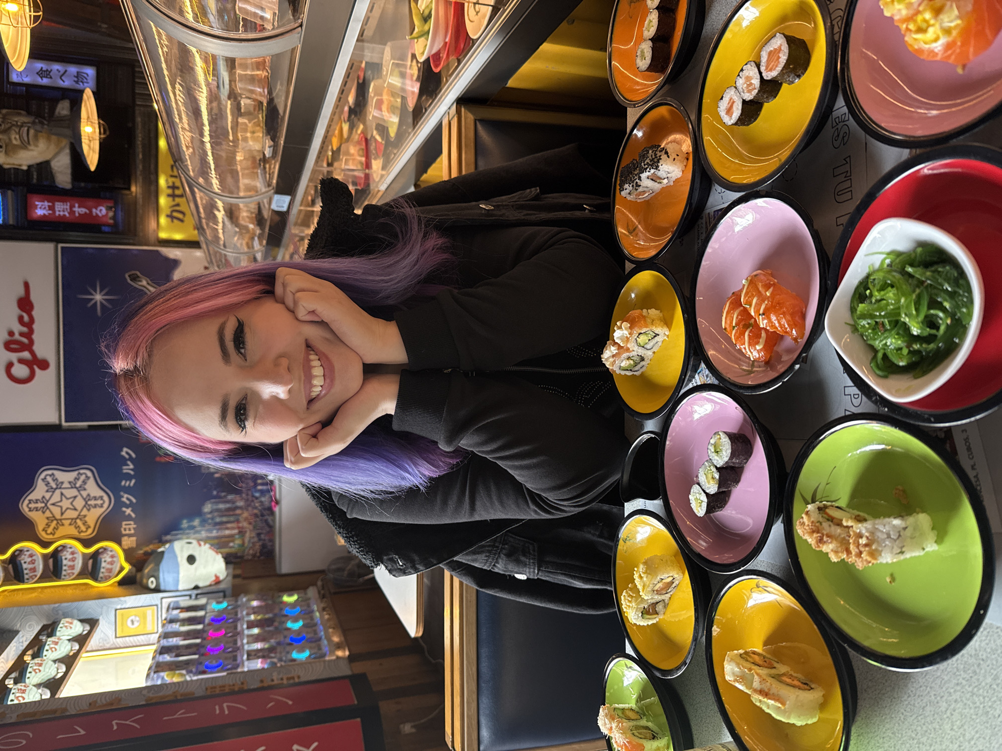 Woman with colorful hair enjoys sushi dining in Madrid