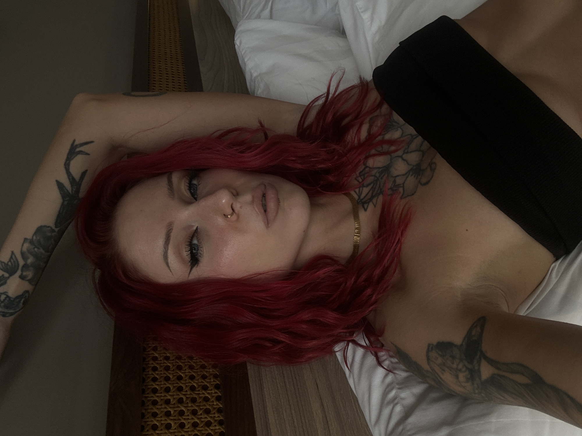 Woman with red hair observed resting in Indonesian bedroom