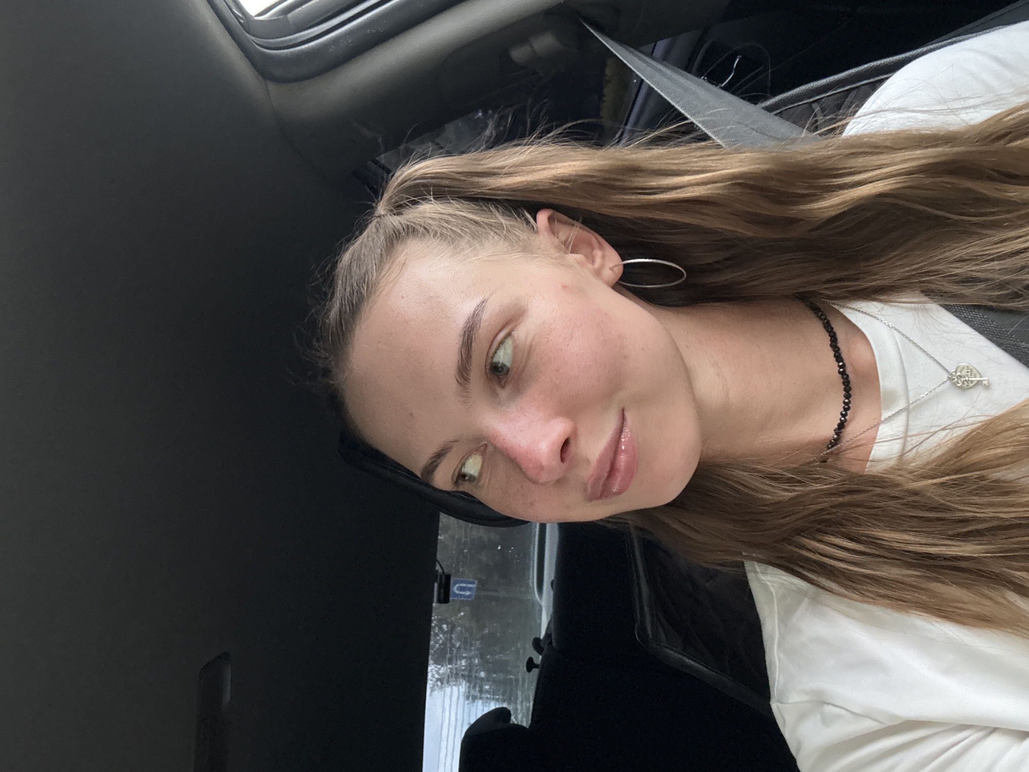 Woman takes selfies in car during afternoon in Perm