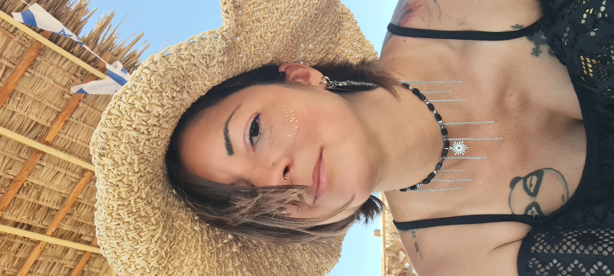 Woman relaxes under beach umbrella in sunny Eilat morning