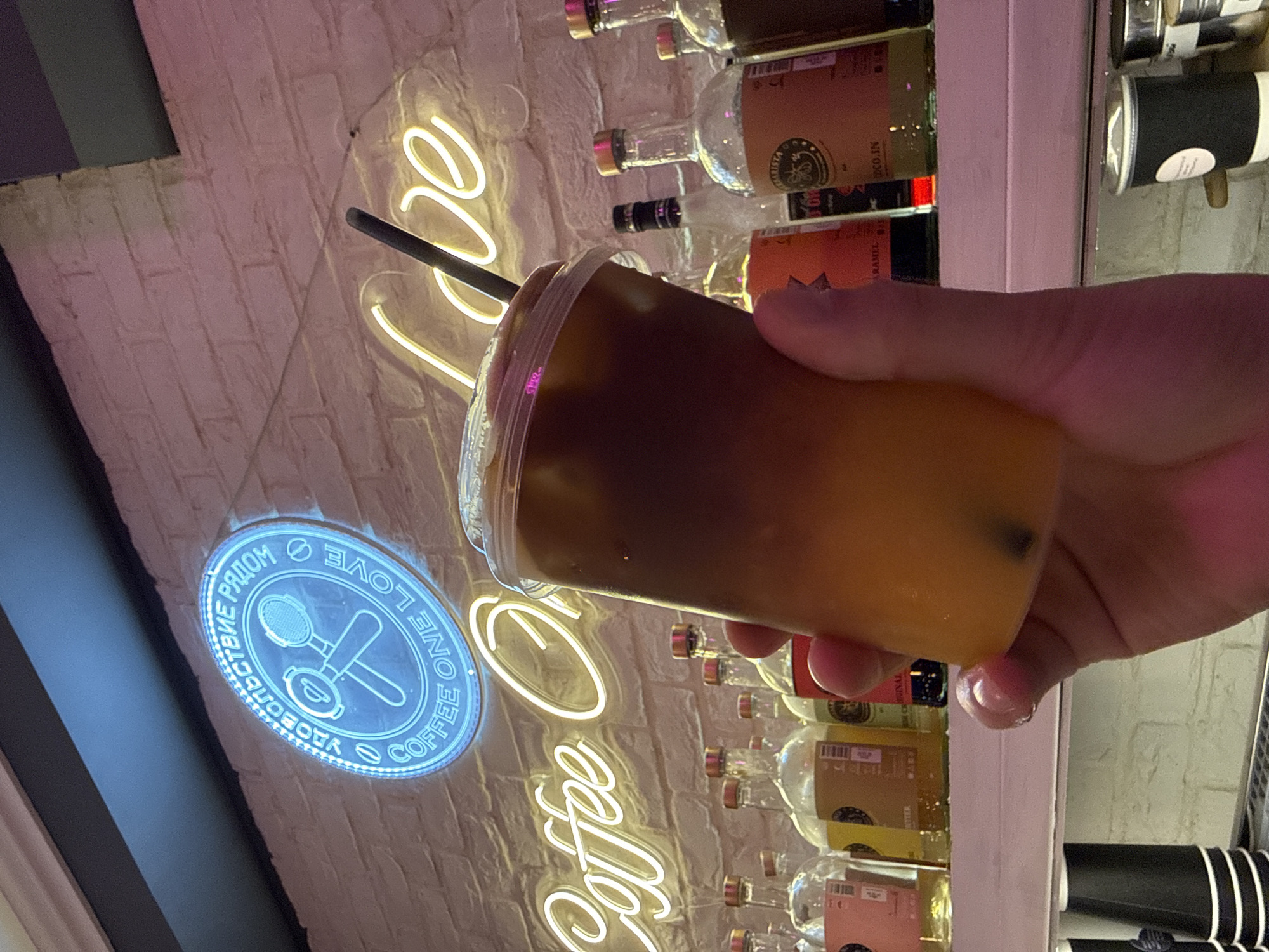 Person holds layered iced coffee drink in Khimki