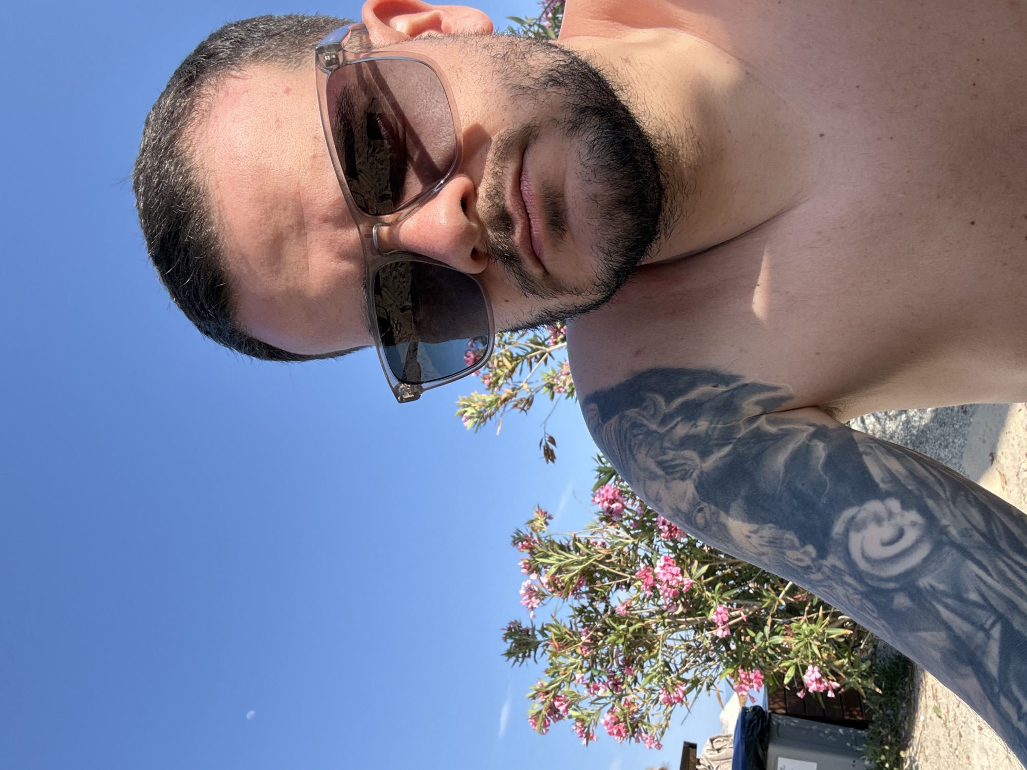 Tourist takes selfie among pink flowers in Kos, Greece