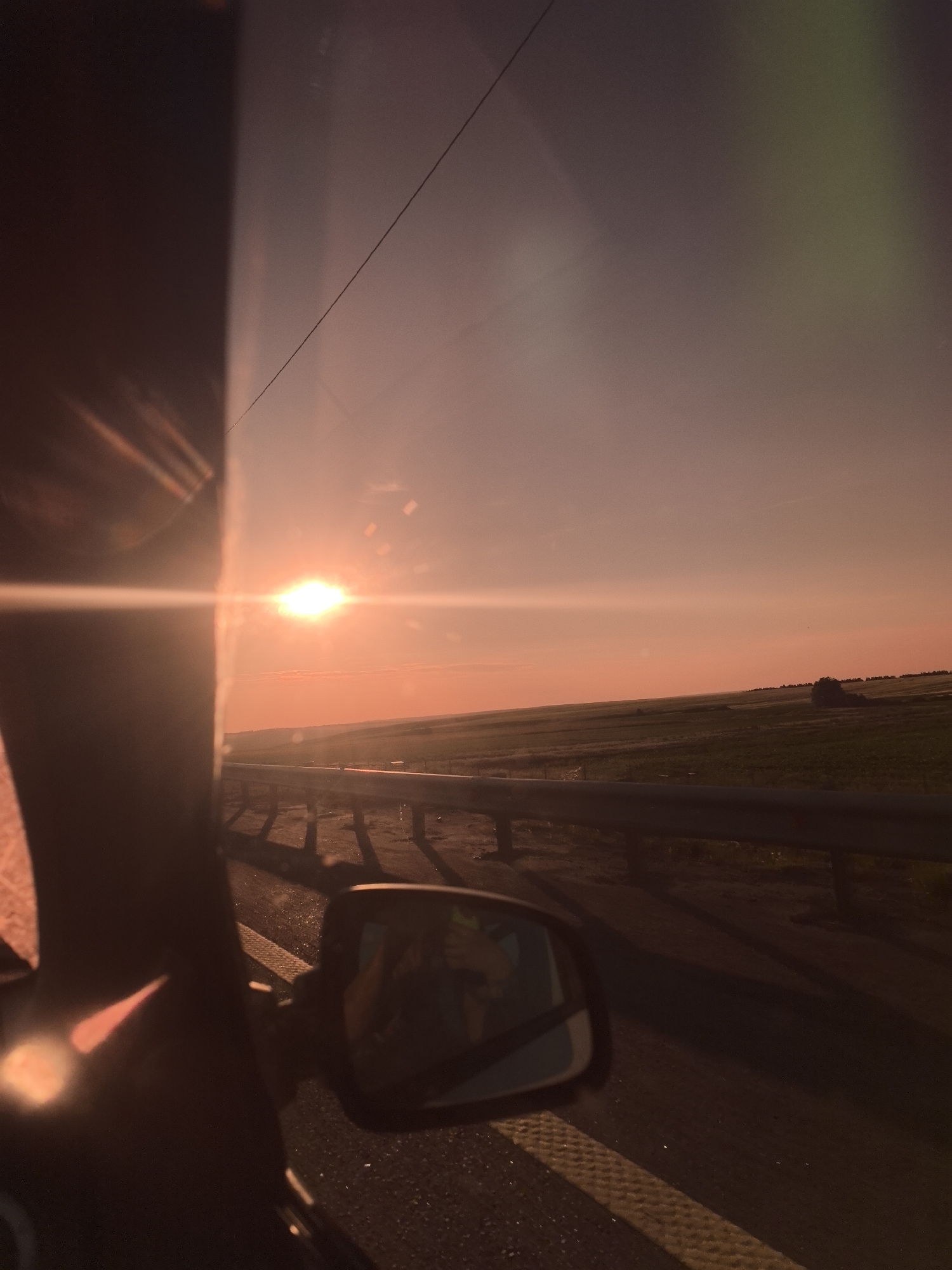 Golden hour sunset through a windshield on a Russian road